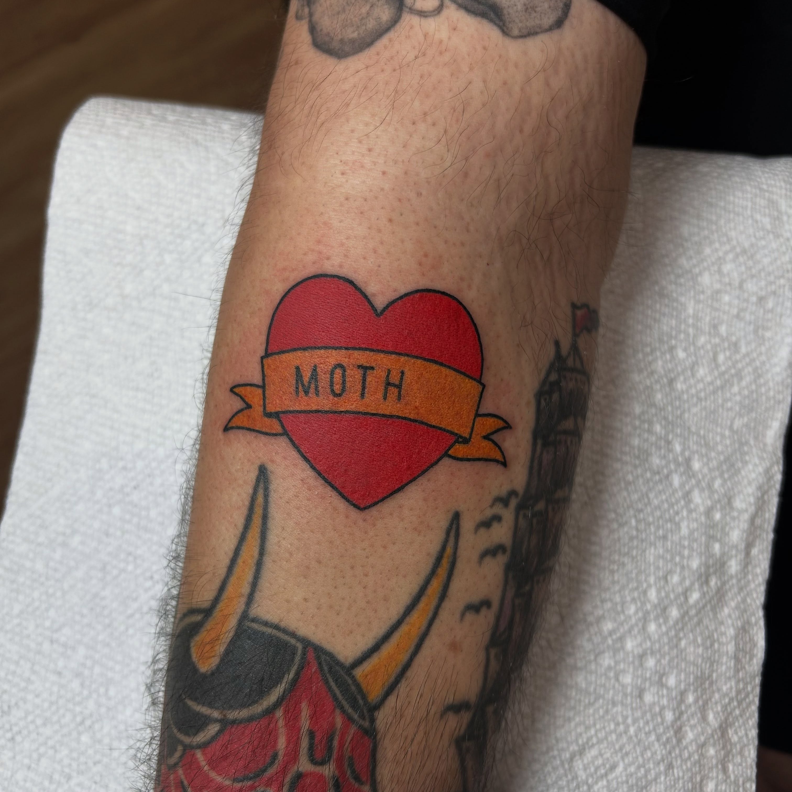 Heart with ribbon American traditional tattoo on the forearm by Stephen Sanchez