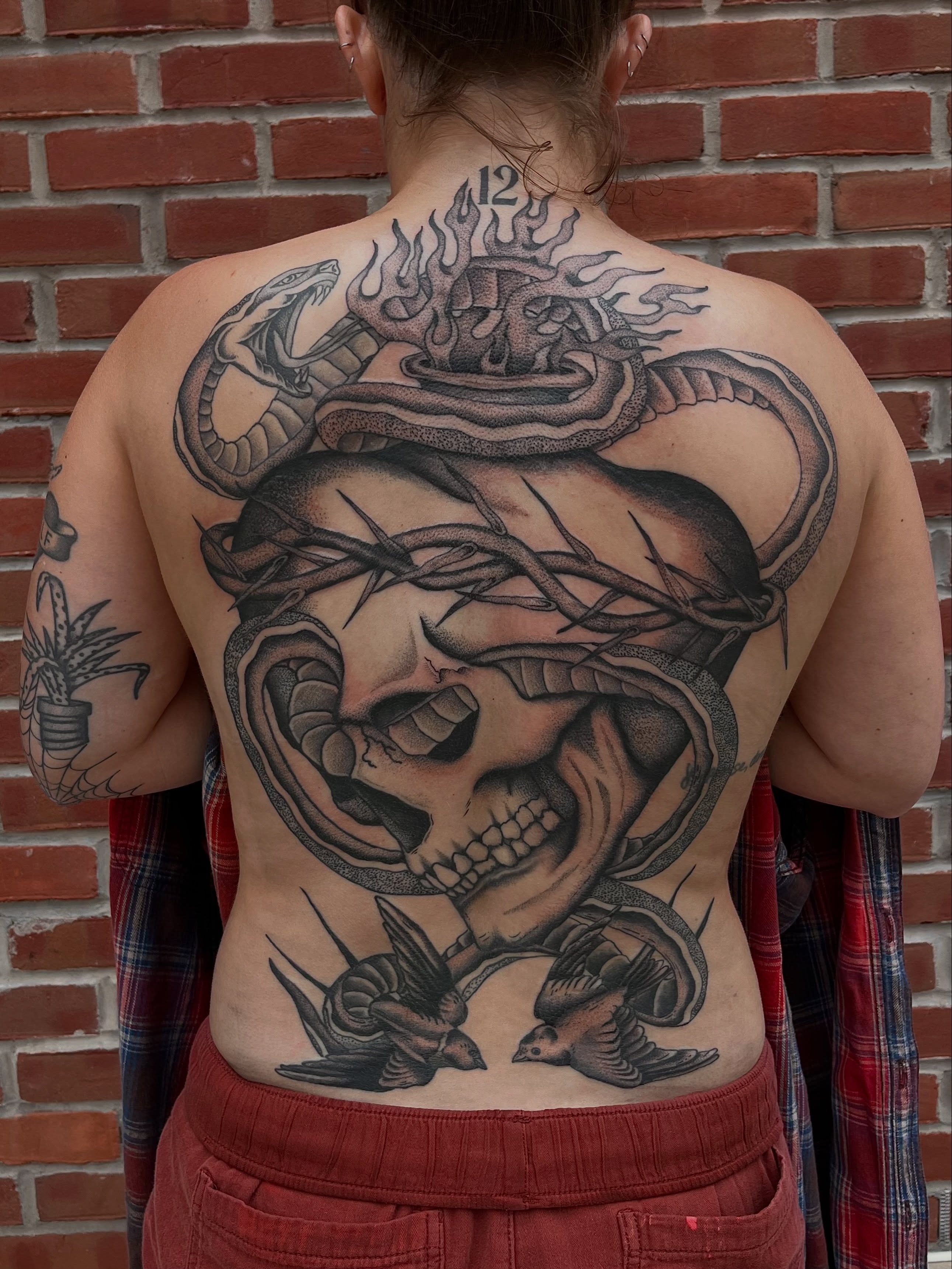 Skull with snake realism tattoo on the back by Jackson Kirchhoff