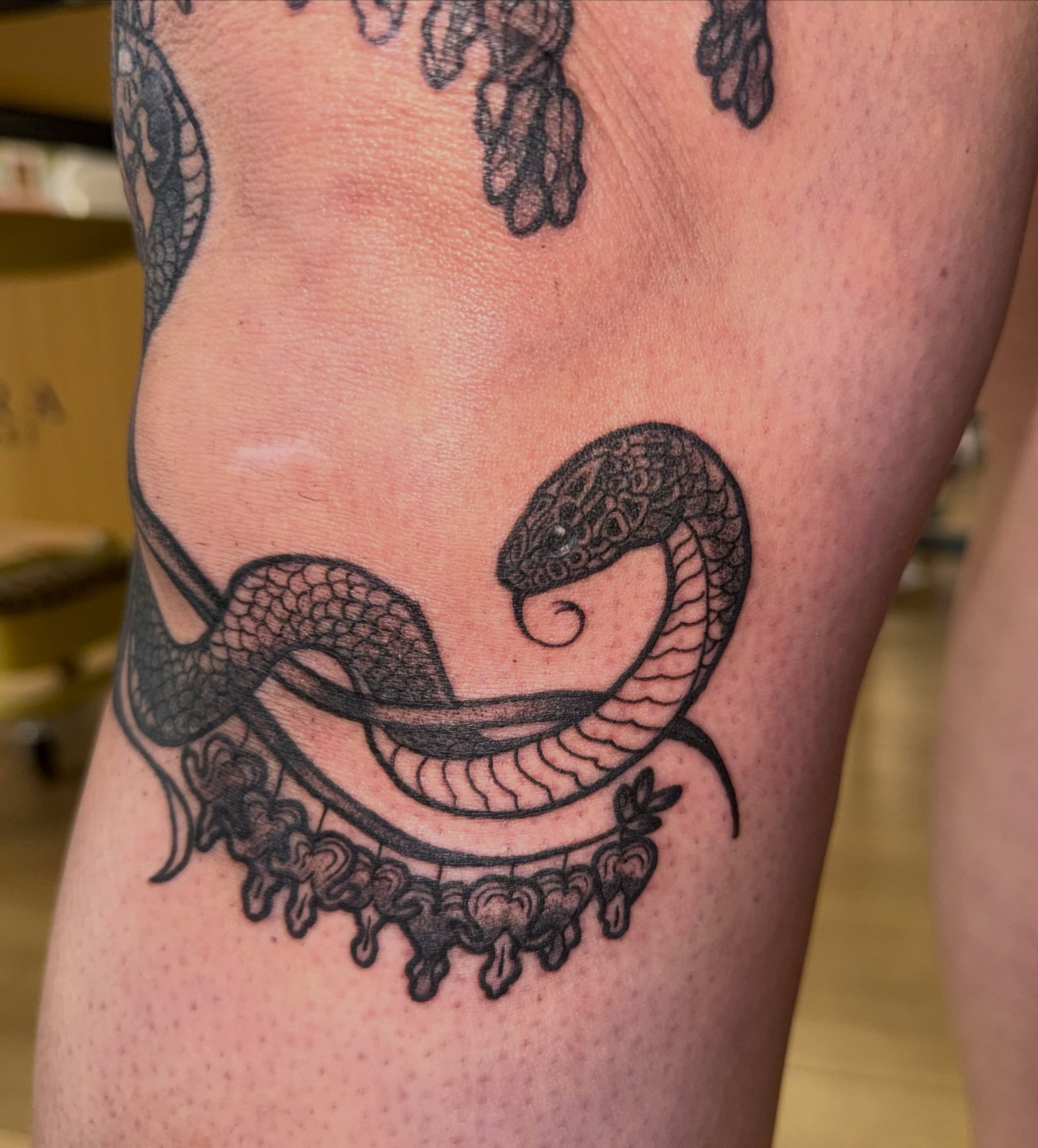 Snake black and grey tattoo on the thigh by Laurito