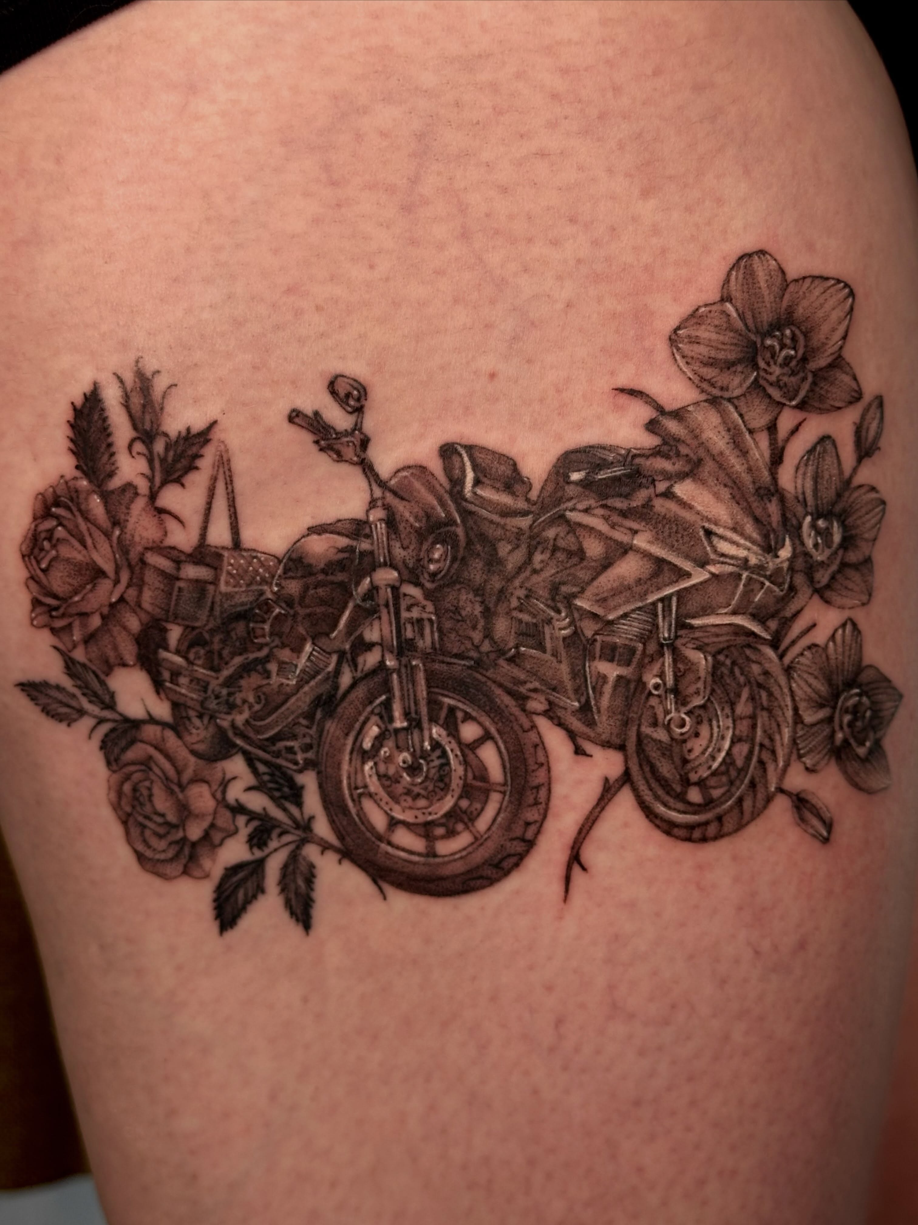 Motorcycle and floral arrangement black and grey tattoo on the shoulder by cora cupid