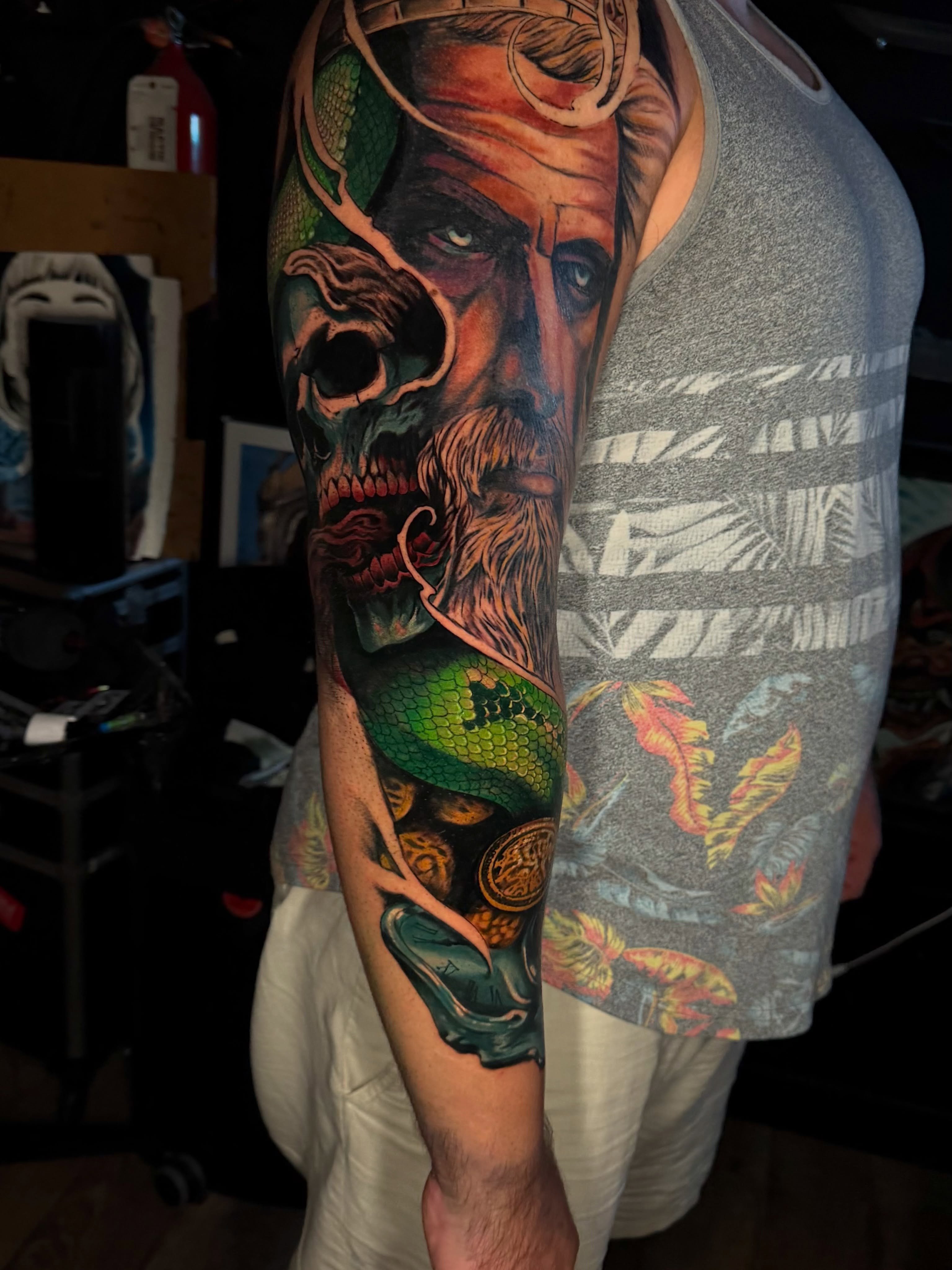 Bearded man with snake realism tattoo on the forearm by Dean Rogers