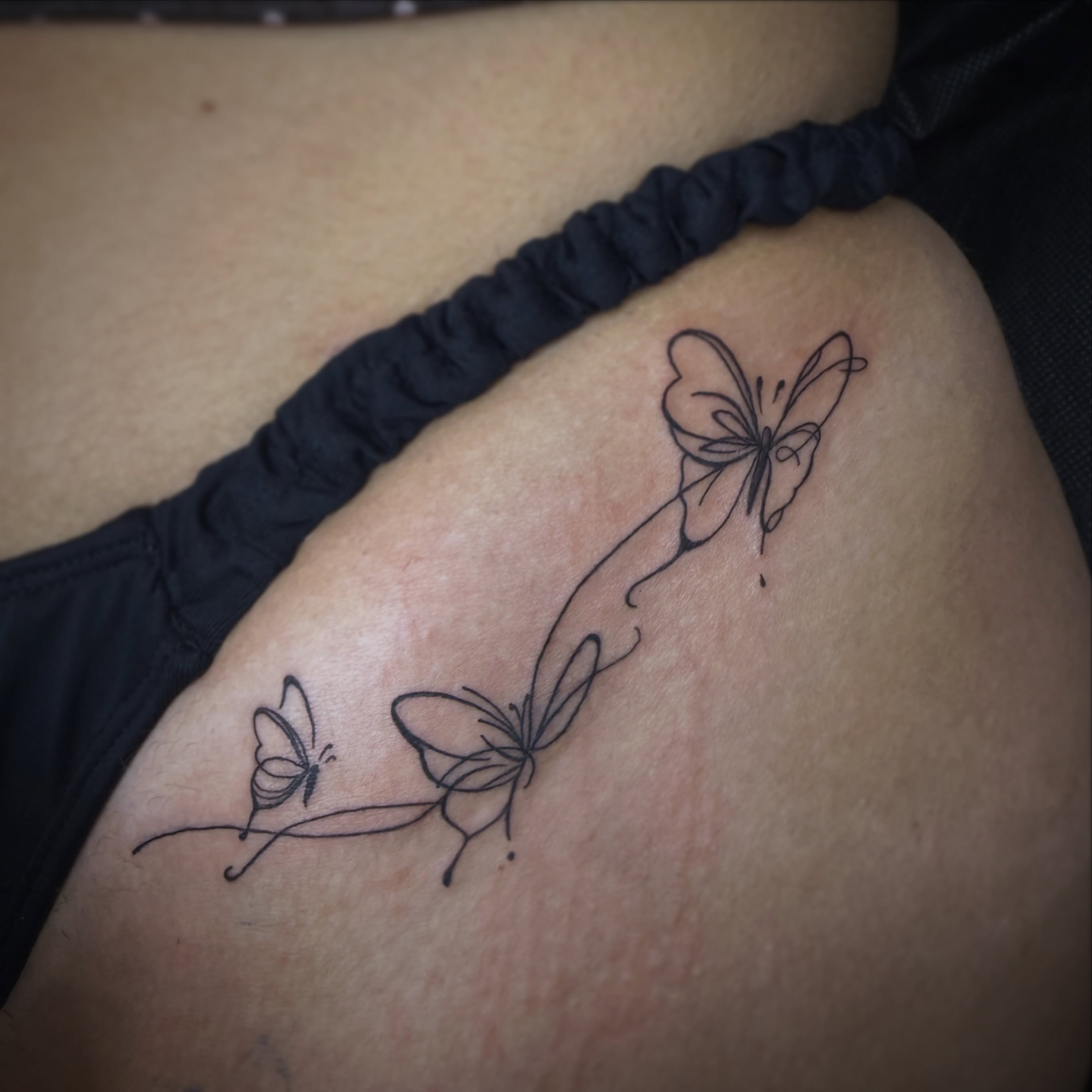 Butterflies black and grey tattoo on the thigh by Kraken ink Tattoo, San Francisco, California