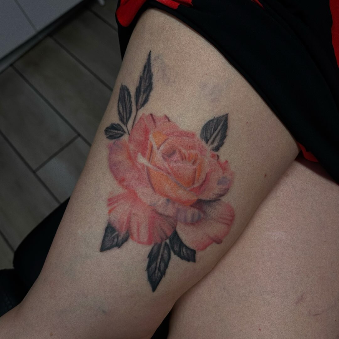 Watercolor rose watercolor tattoo on the thigh by Marly Quinn