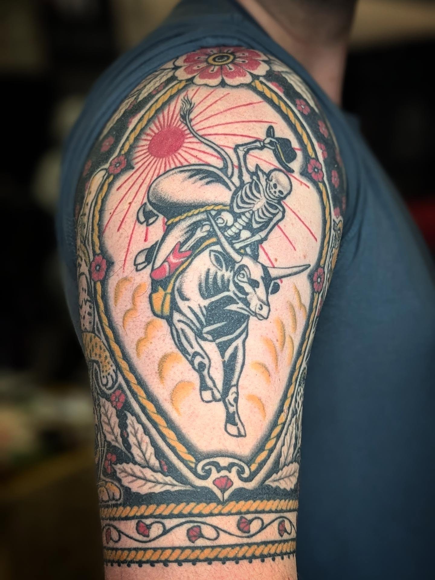 Bull riding skeleton American traditional tattoo on the upper arm by Eli Studer