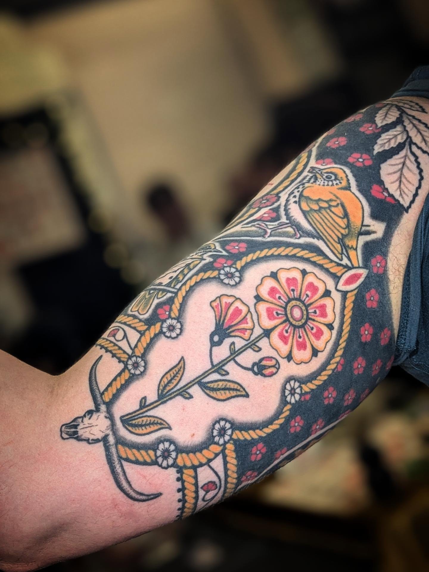 Bird and floral arrangement American traditional tattoo on the forearm by Eli Studer