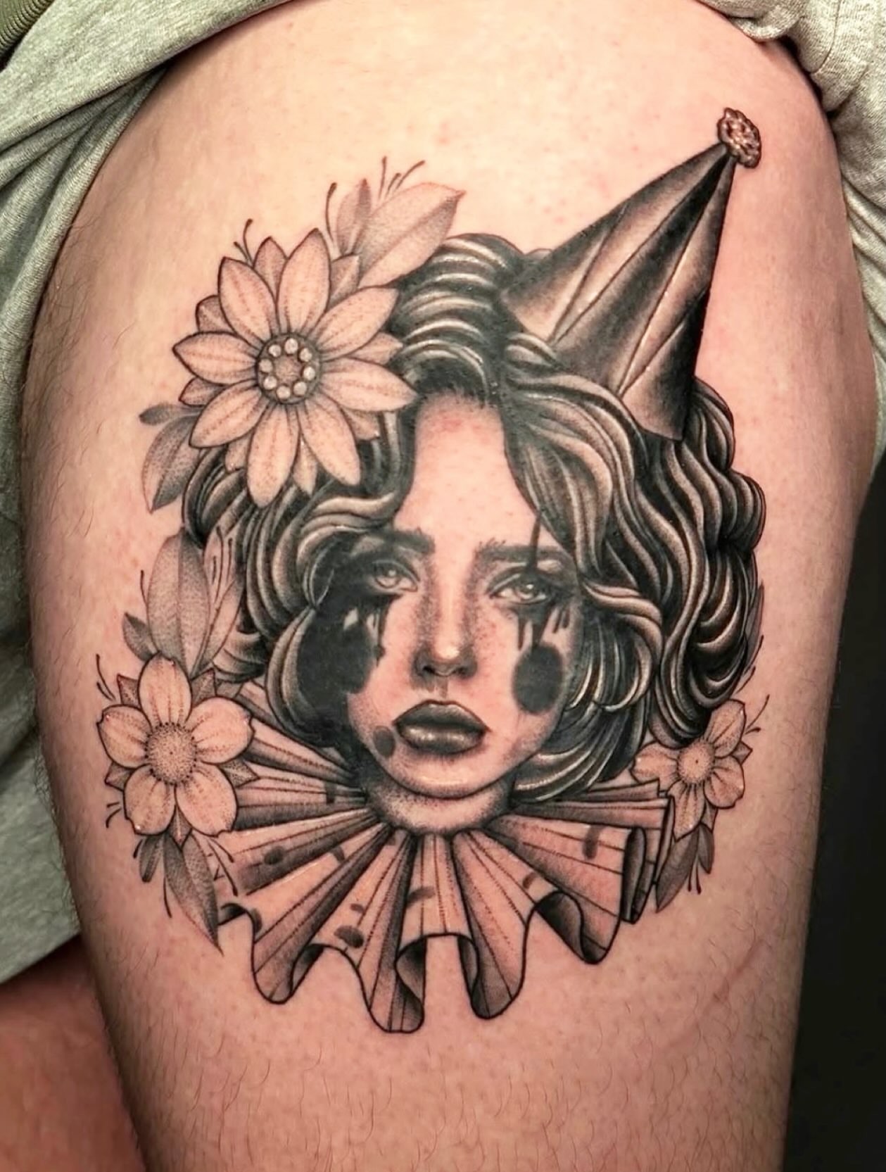 Clown black and grey tattoo on the thigh by Giovanna Kline
