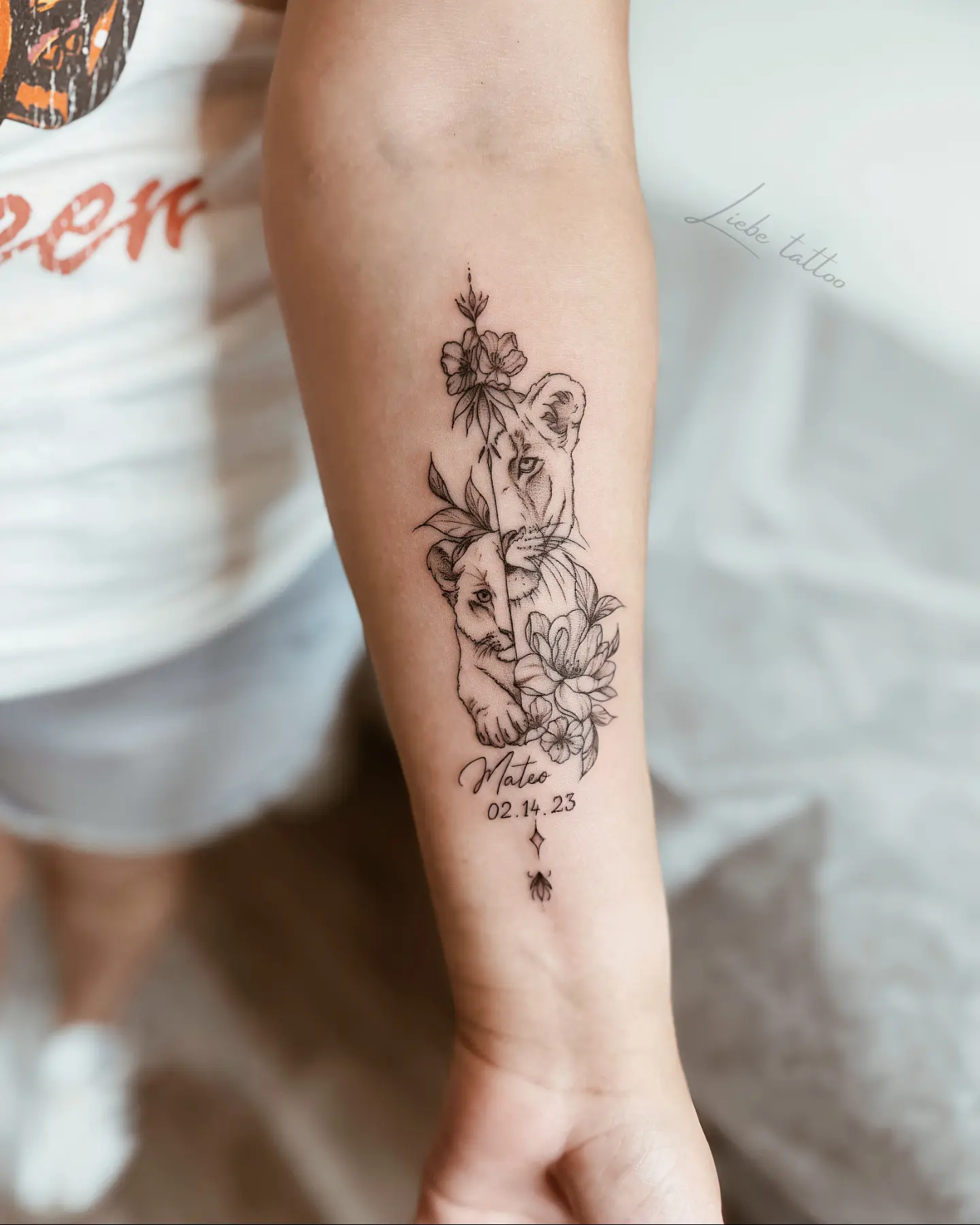 Lion and flowers black and grey tattoo on the forearm by Floral Fineline Tattoo