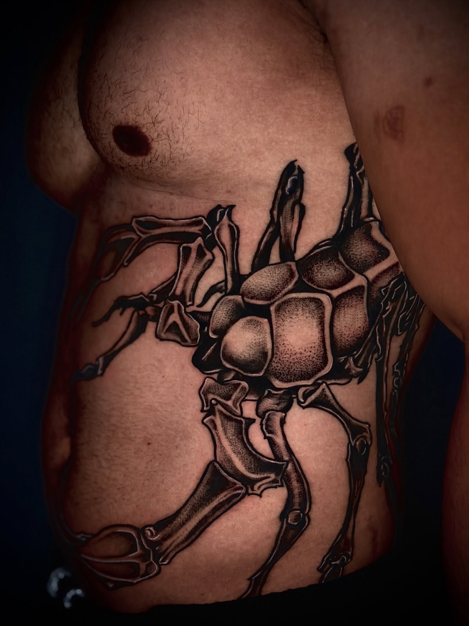 Spider geometric tattoo on the chest by Giovanna Kline