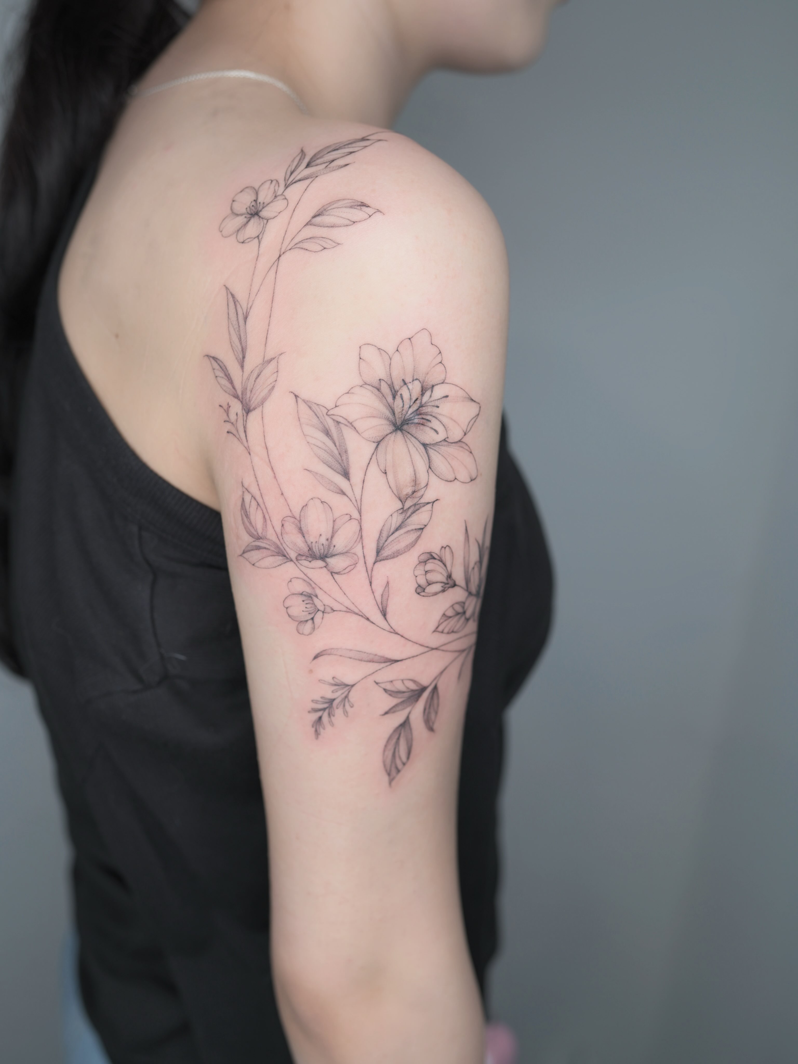 Floral arrangement black and grey tattoo on the upper arm by Seattle tattoo artist-Mia