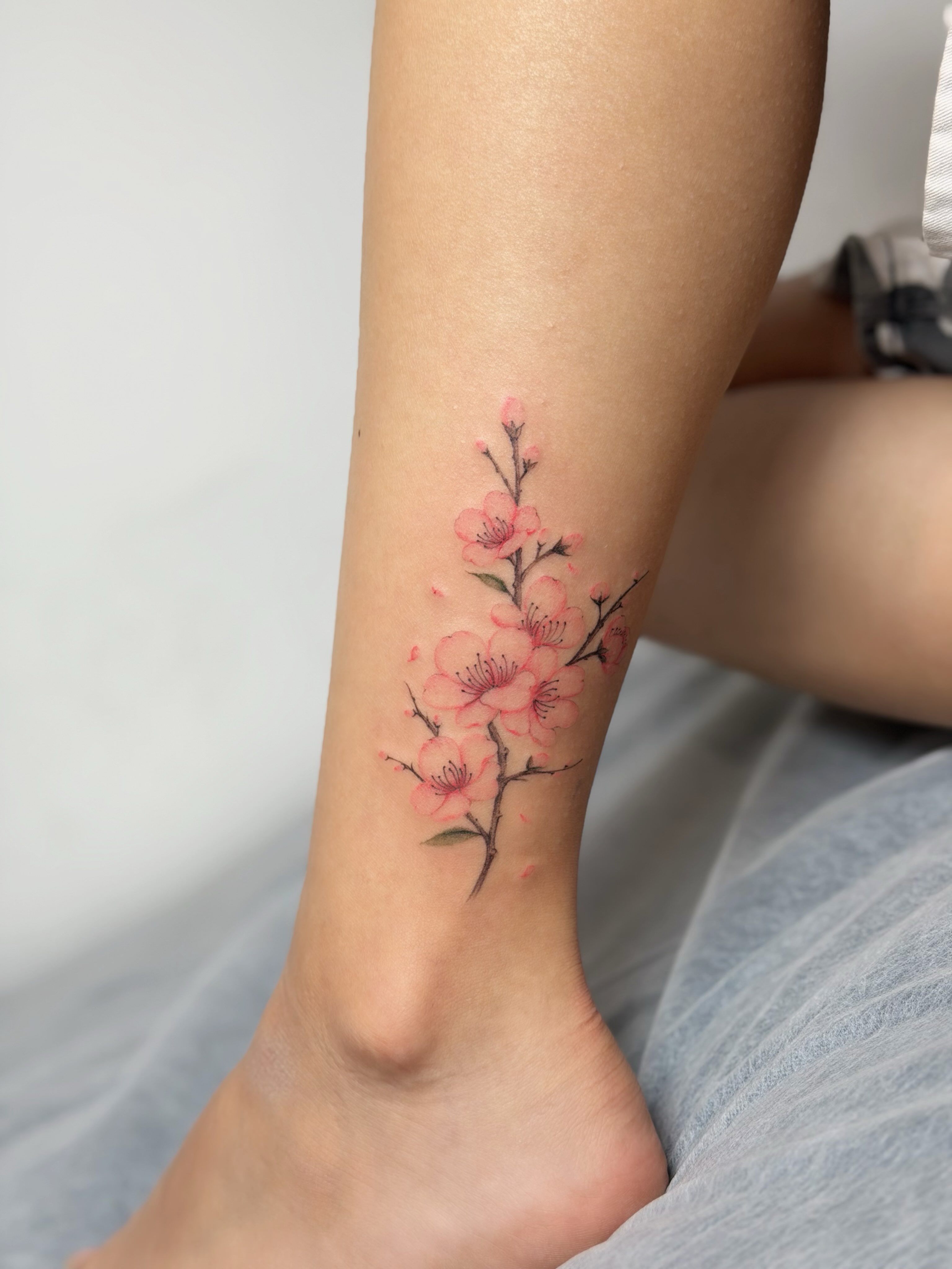 Cherry blossoms watercolor tattoo on the calf by Seattle tattoo artist-Mia