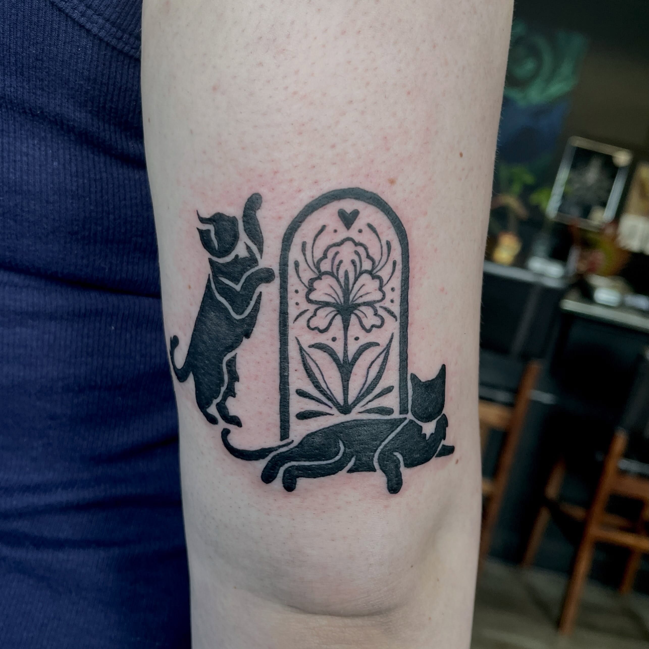 Cats and floral arch black and grey tattoo on the forearm by sarah