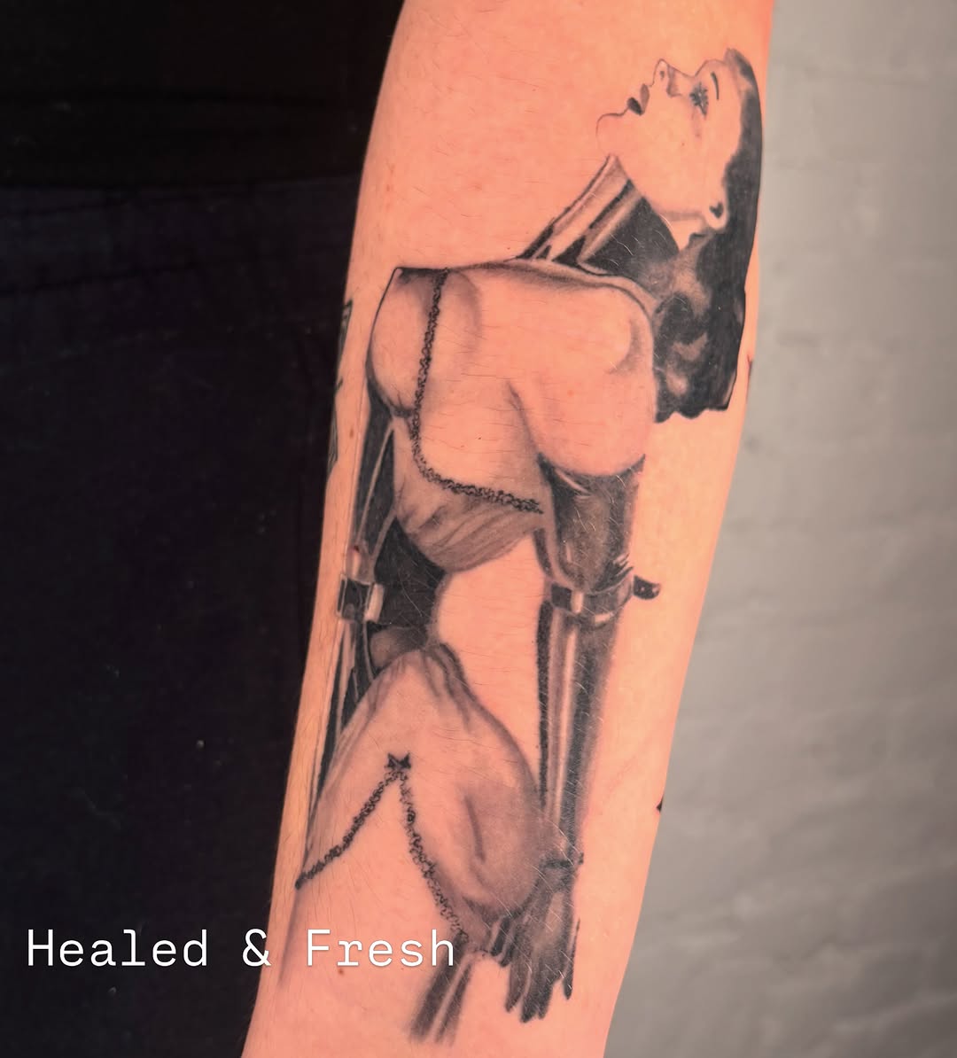 Woman in harness black and grey tattoo on the forearm by laura bianca
