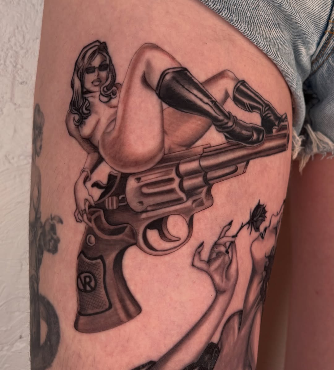 Gun and woman realism tattoo on the thigh by laura bianca