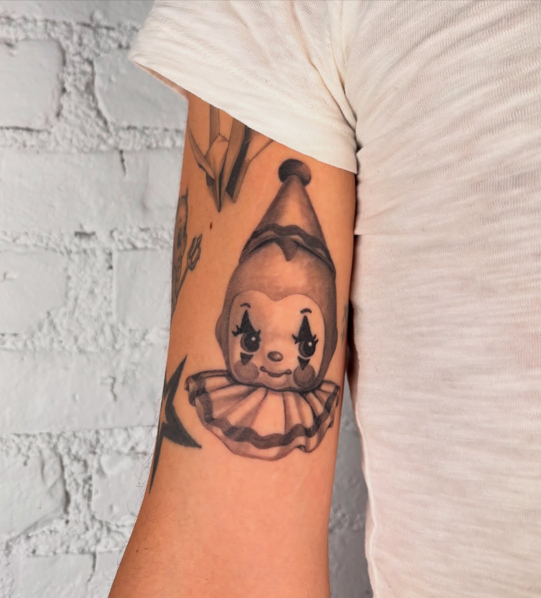 Clown black and grey tattoo on the forearm by laura bianca