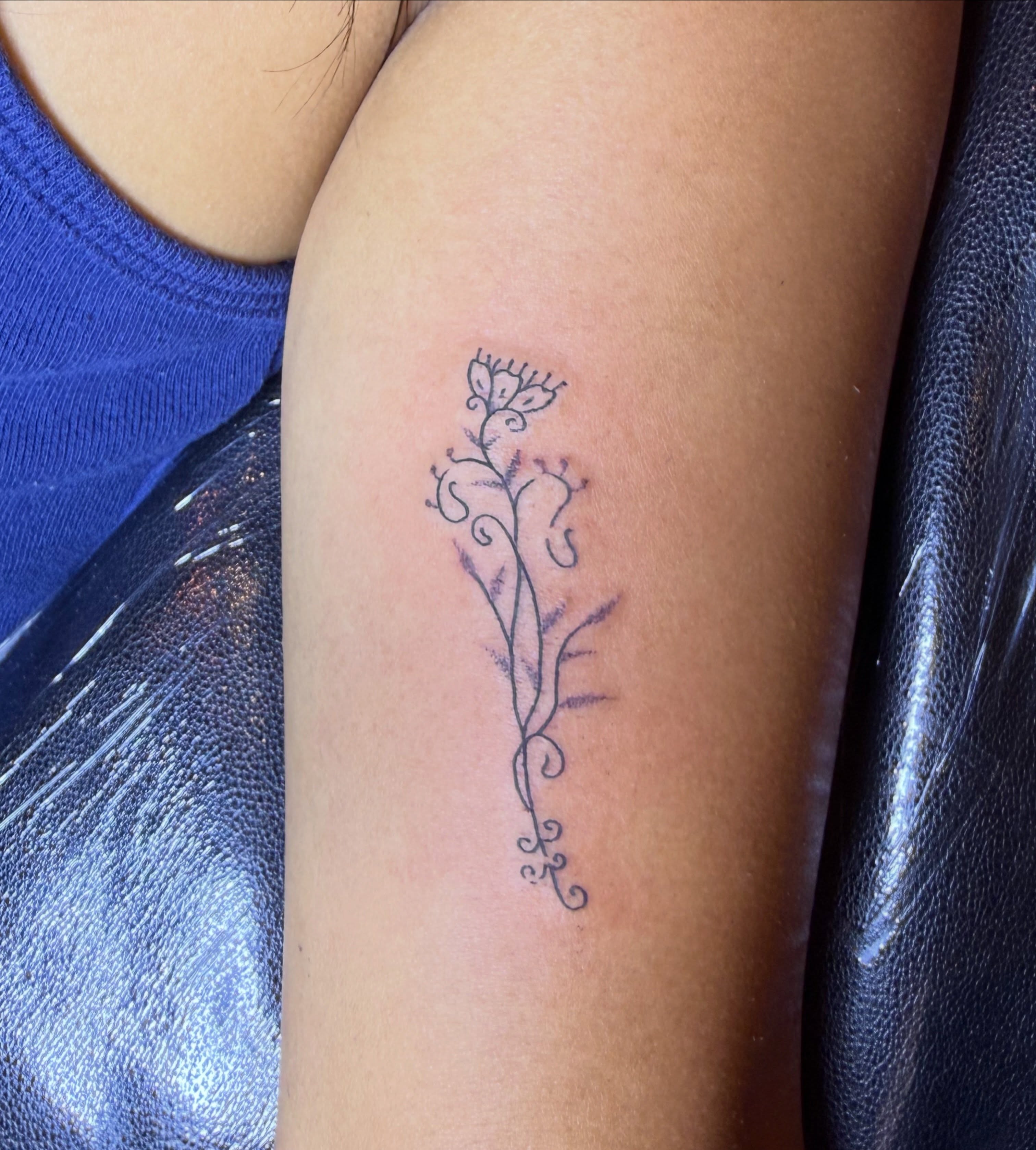 Flower vine fine line tattoo on the forearm by Kieara West