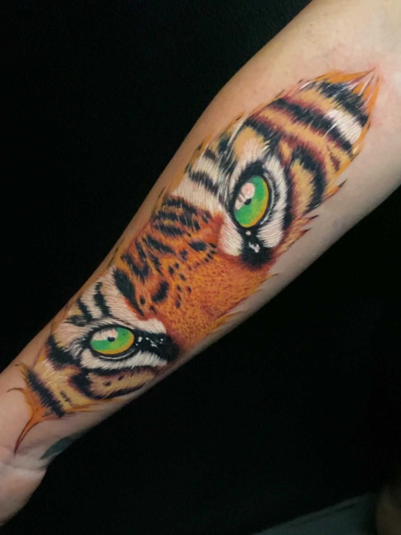 Tiger eyes realism tattoo on the forearm by Alex