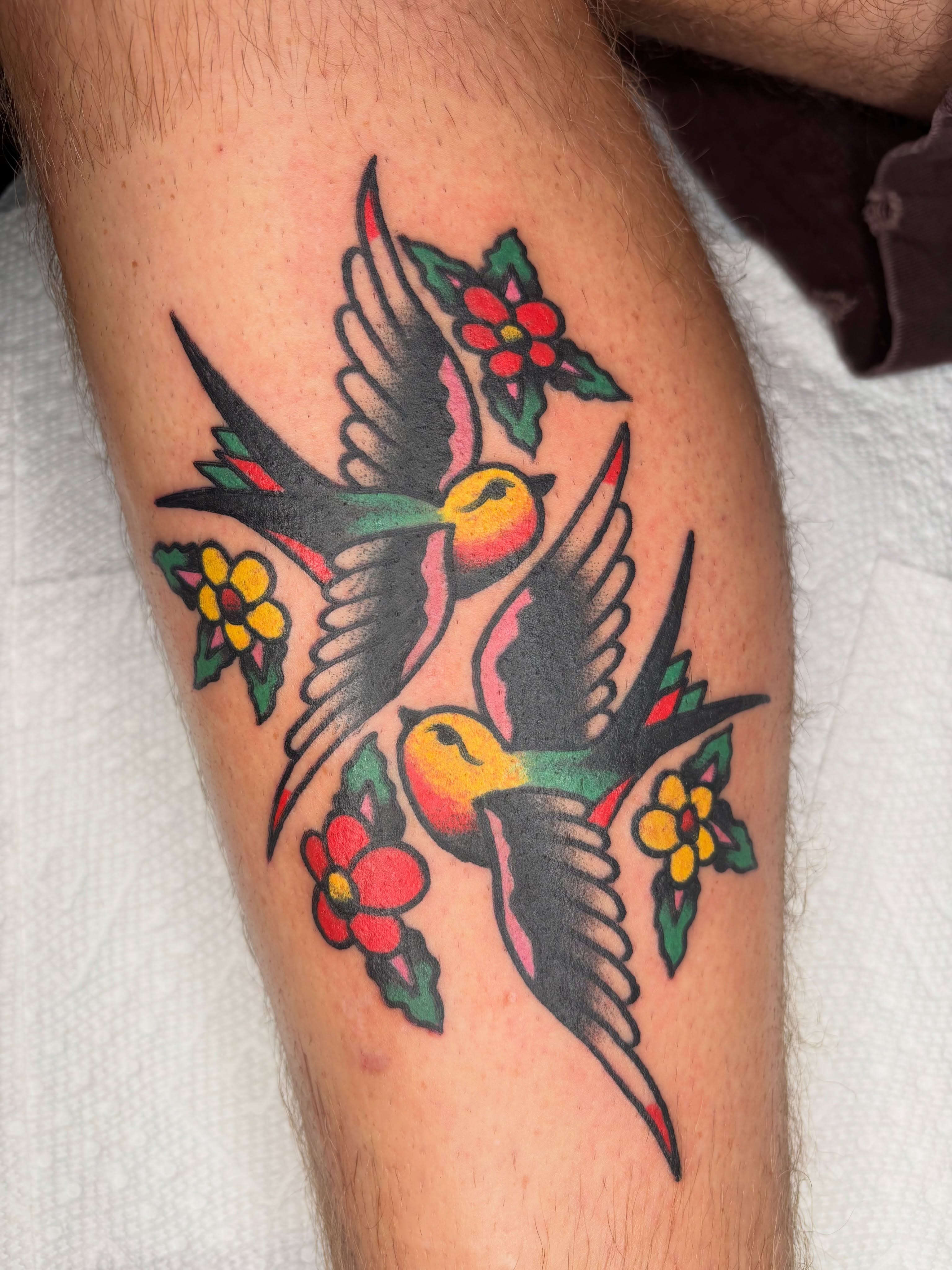Swallows and flowers American traditional tattoo on the thigh by Cooper Reichwein