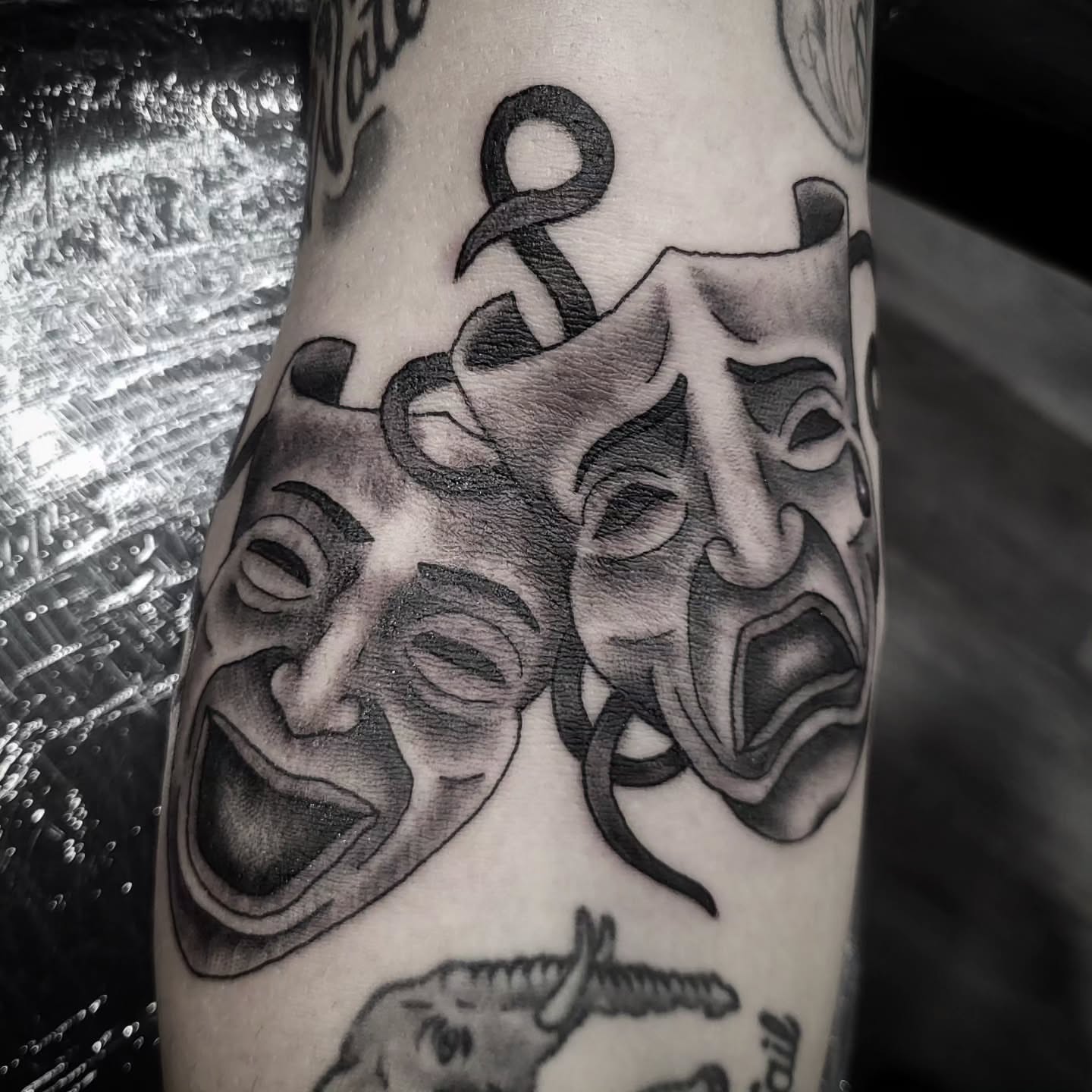 Theater masks realism tattoo on the forearm by Sloan Smith