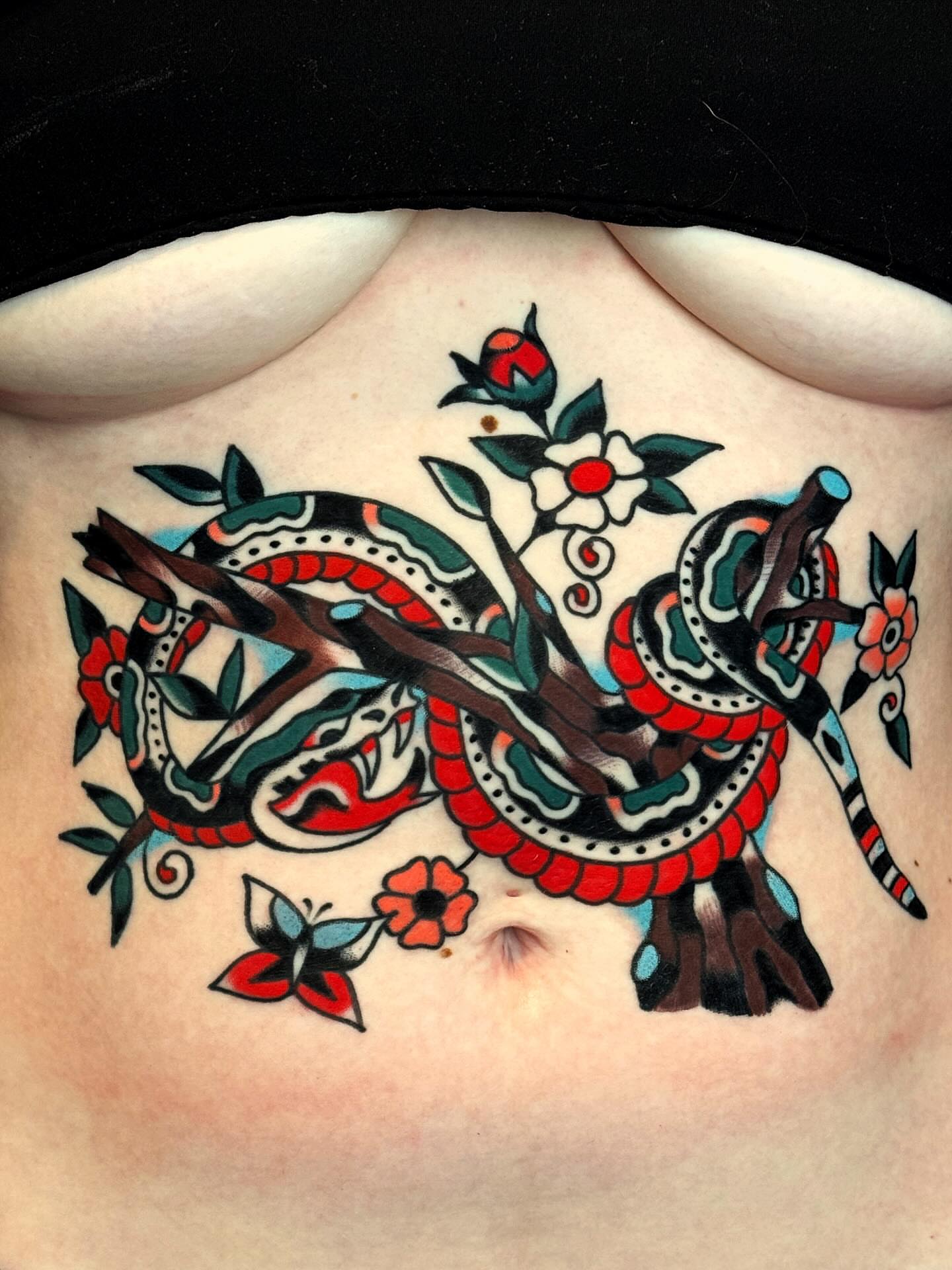 Snake and flowers American traditional tattoo on the chest by Bryce Shearer