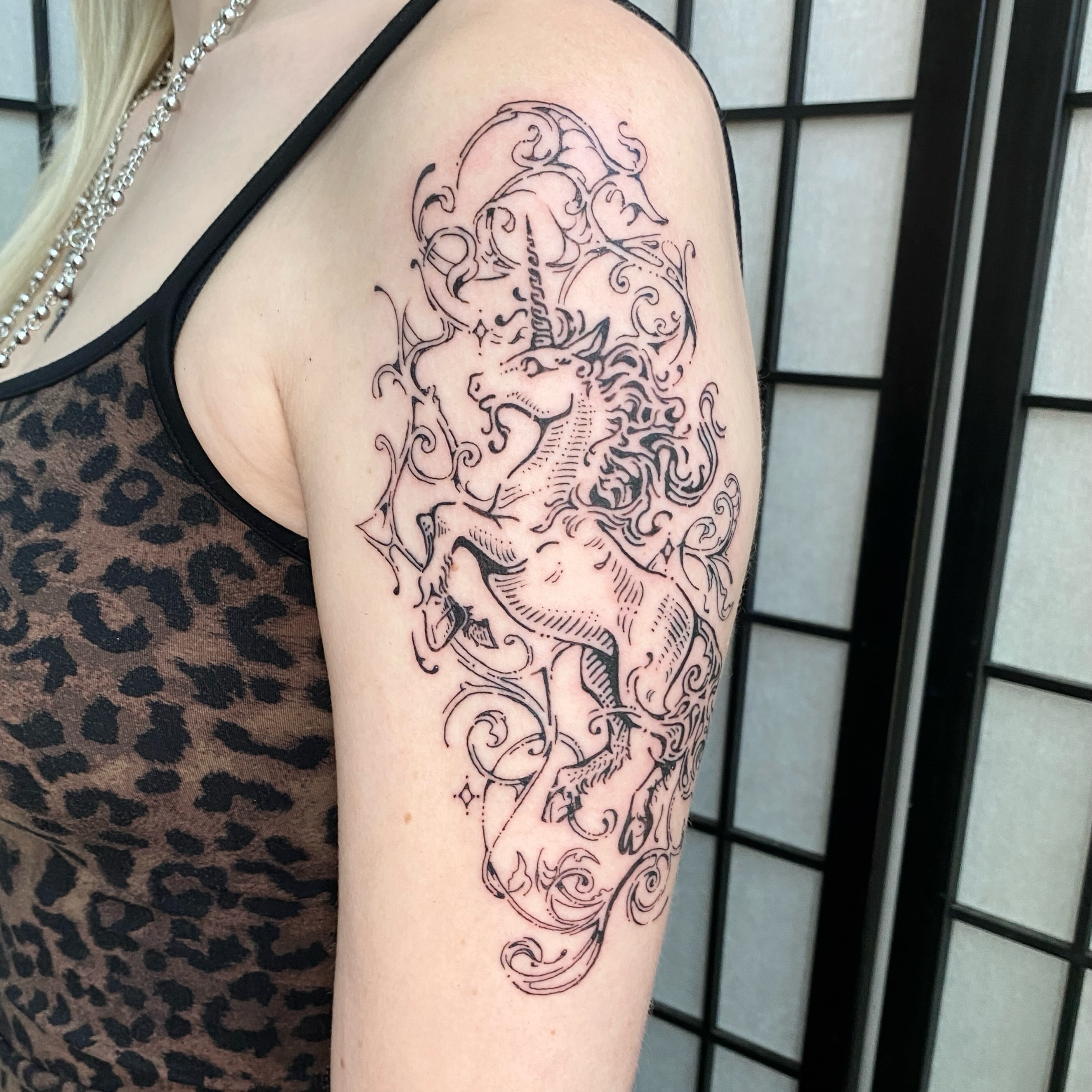 Unicorn black and grey tattoo on the shoulder by Clara