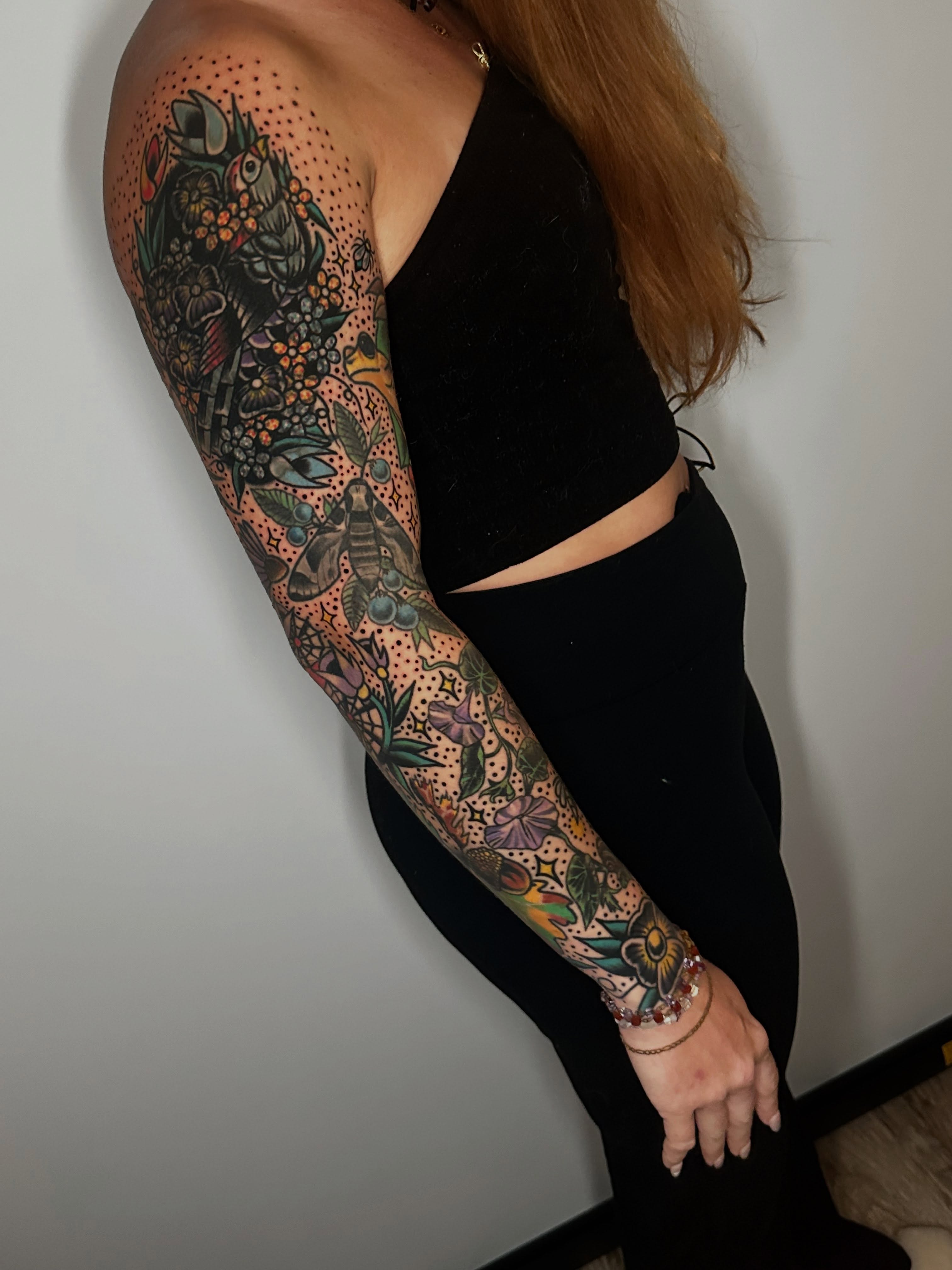 Floral and insect motifs dotwork tattoo on the upper arm by Spencer Crawford, Speedway, Indiana