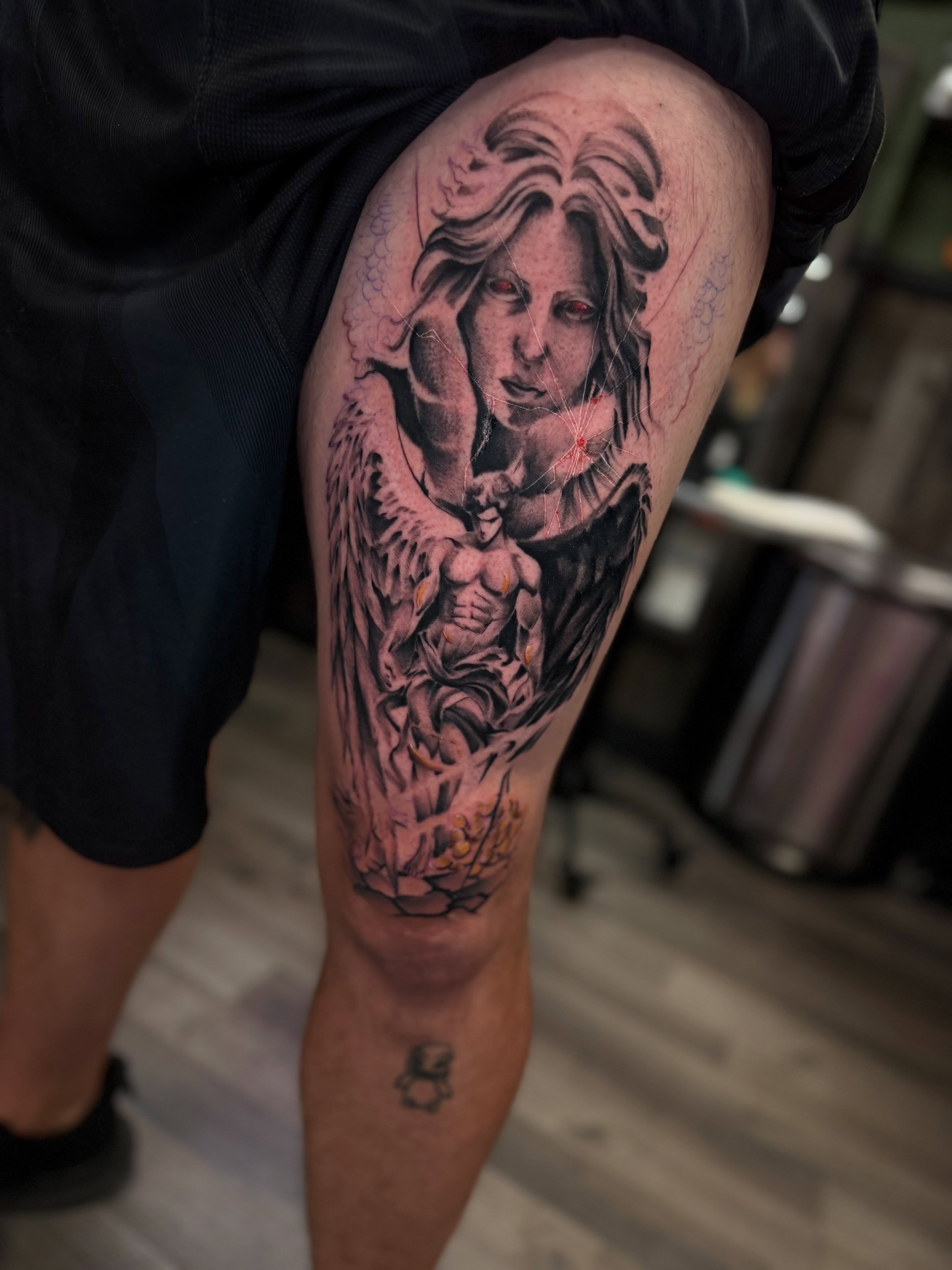 Woman with wings realism tattoo on the thigh by Ray De Leon