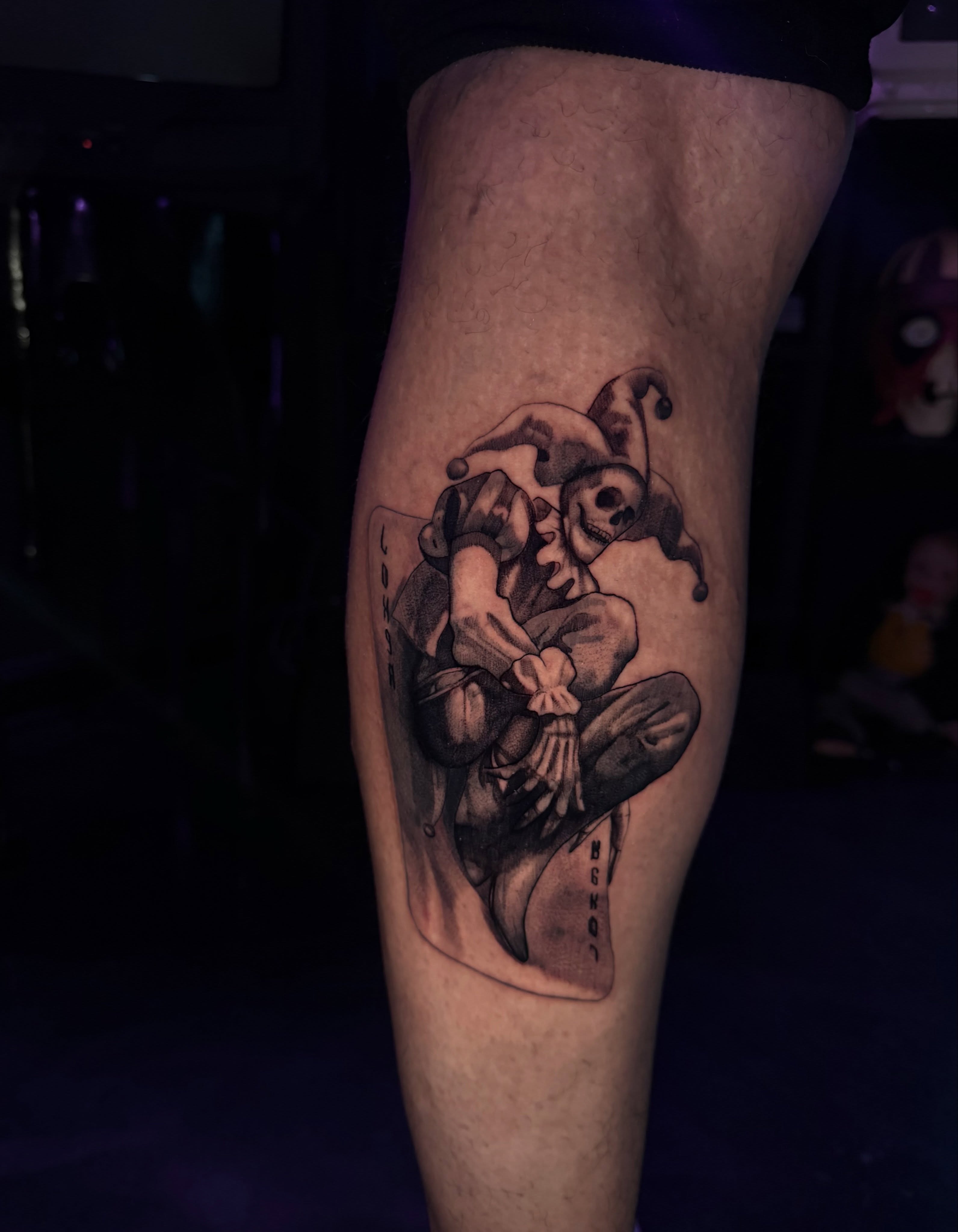 Jester and skull black and grey tattoo on the thigh by Giovanni Rodriguez, Eastpointe, Michigan