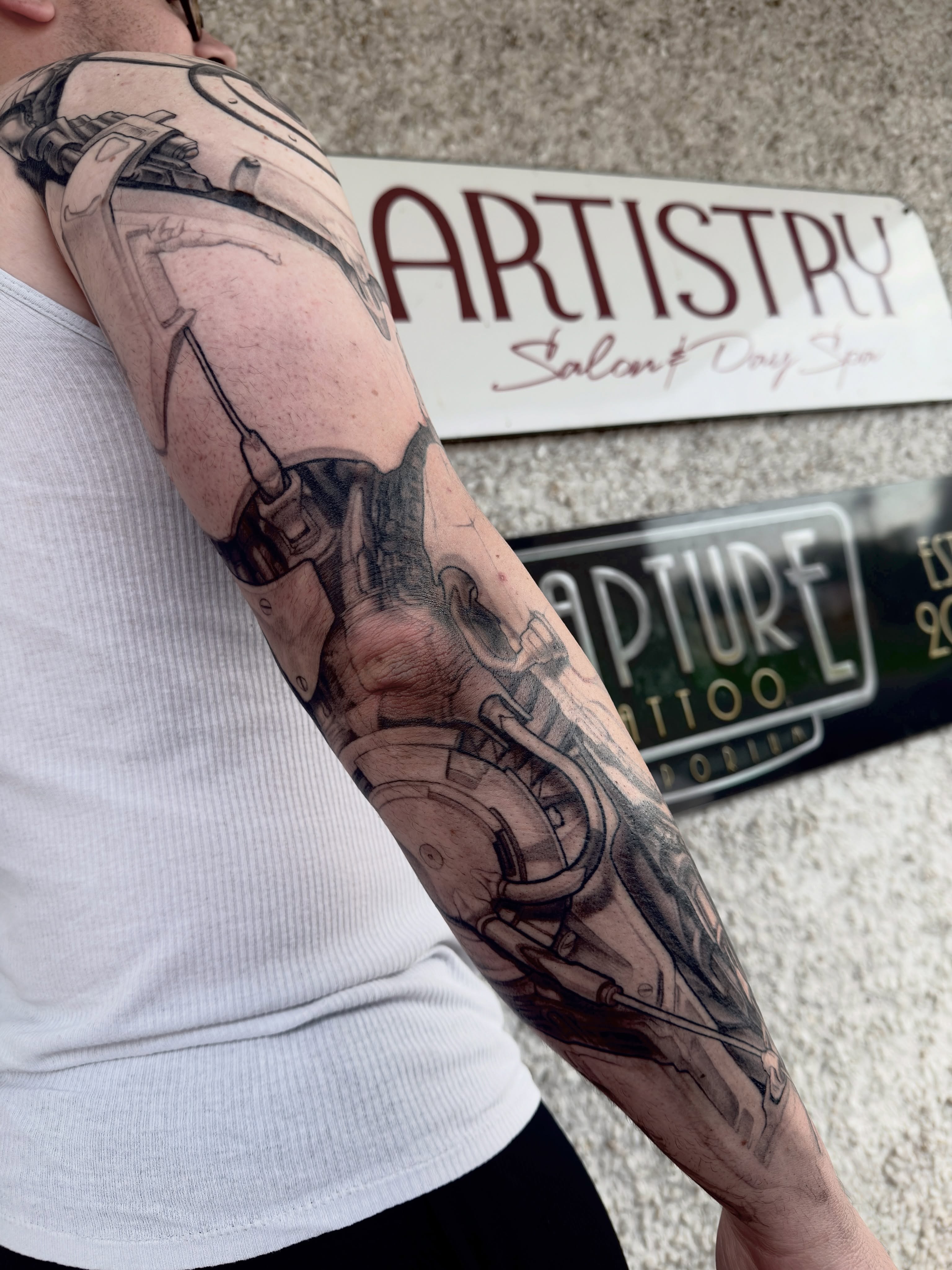Cyberpunk cityscape realism tattoo on the forearm by Jake Kirk