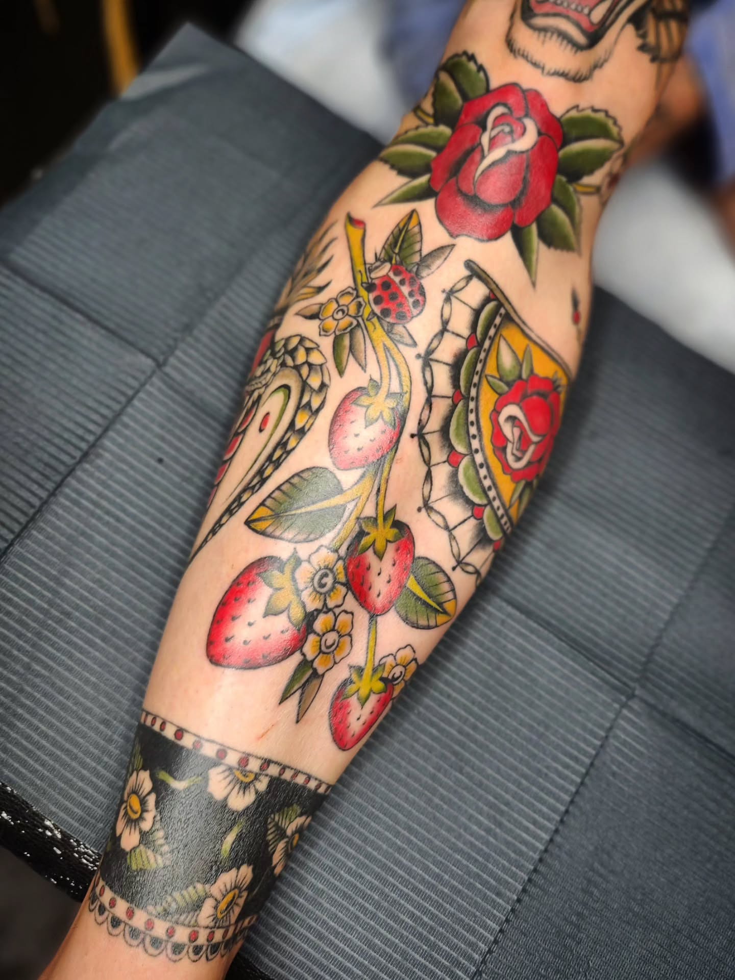 Strawberries and roses American traditional tattoo on the forearm by Kelly Zito
