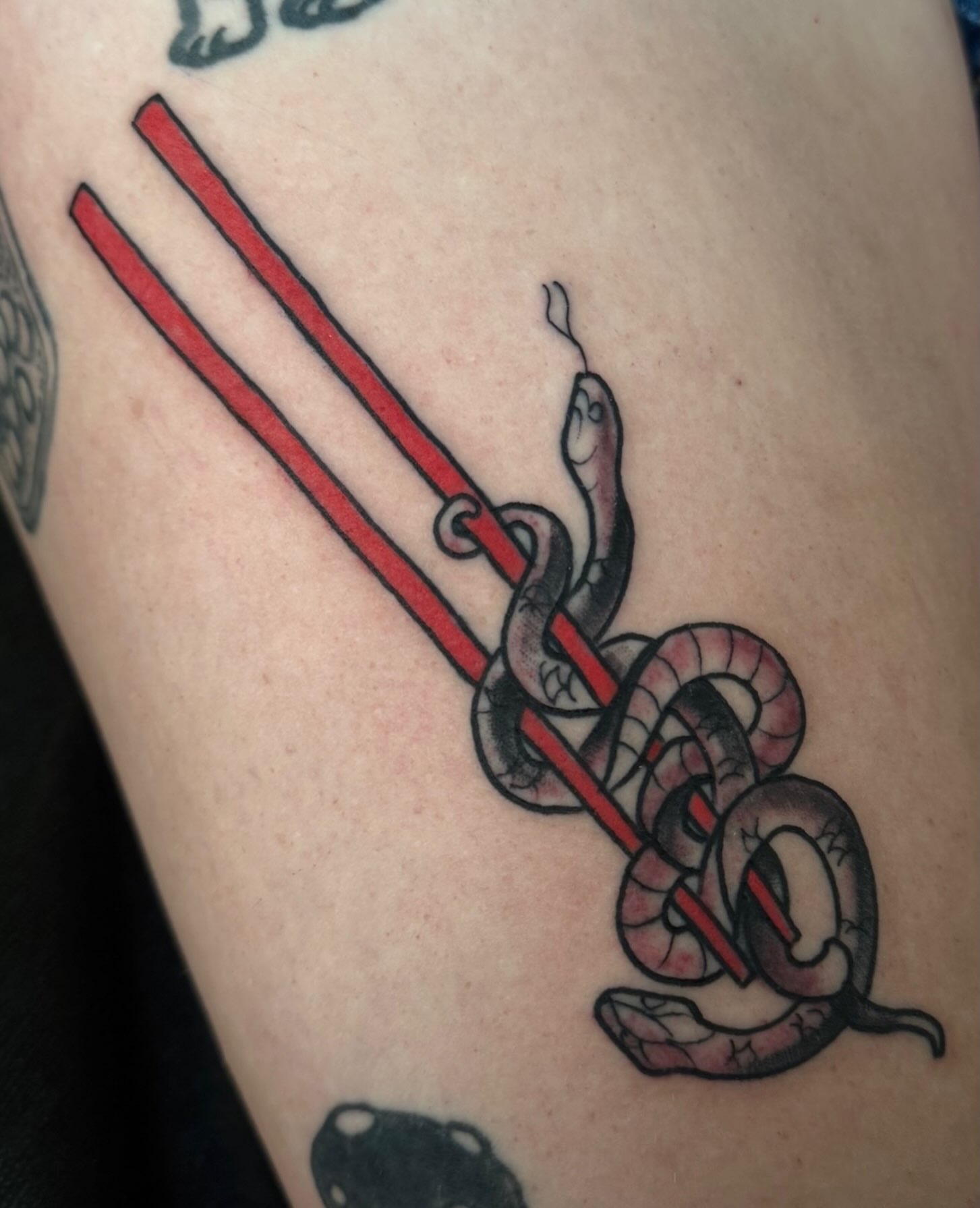 Snake and chopsticks American traditional tattoo on the thigh by Sean Wilcox, Des Moines, Iowa