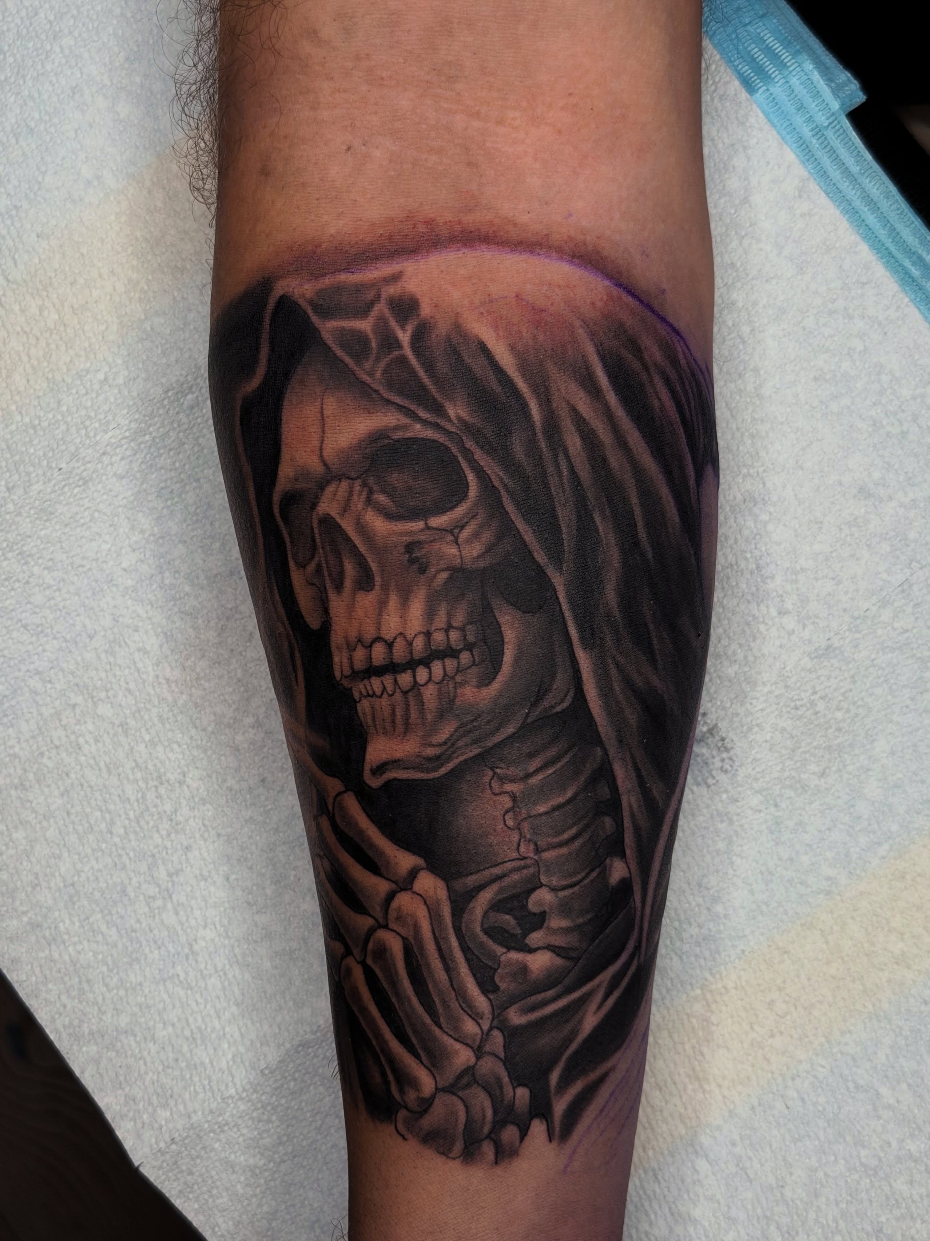Reaper skull dark realism tattoo on the forearm by Caleb Moul