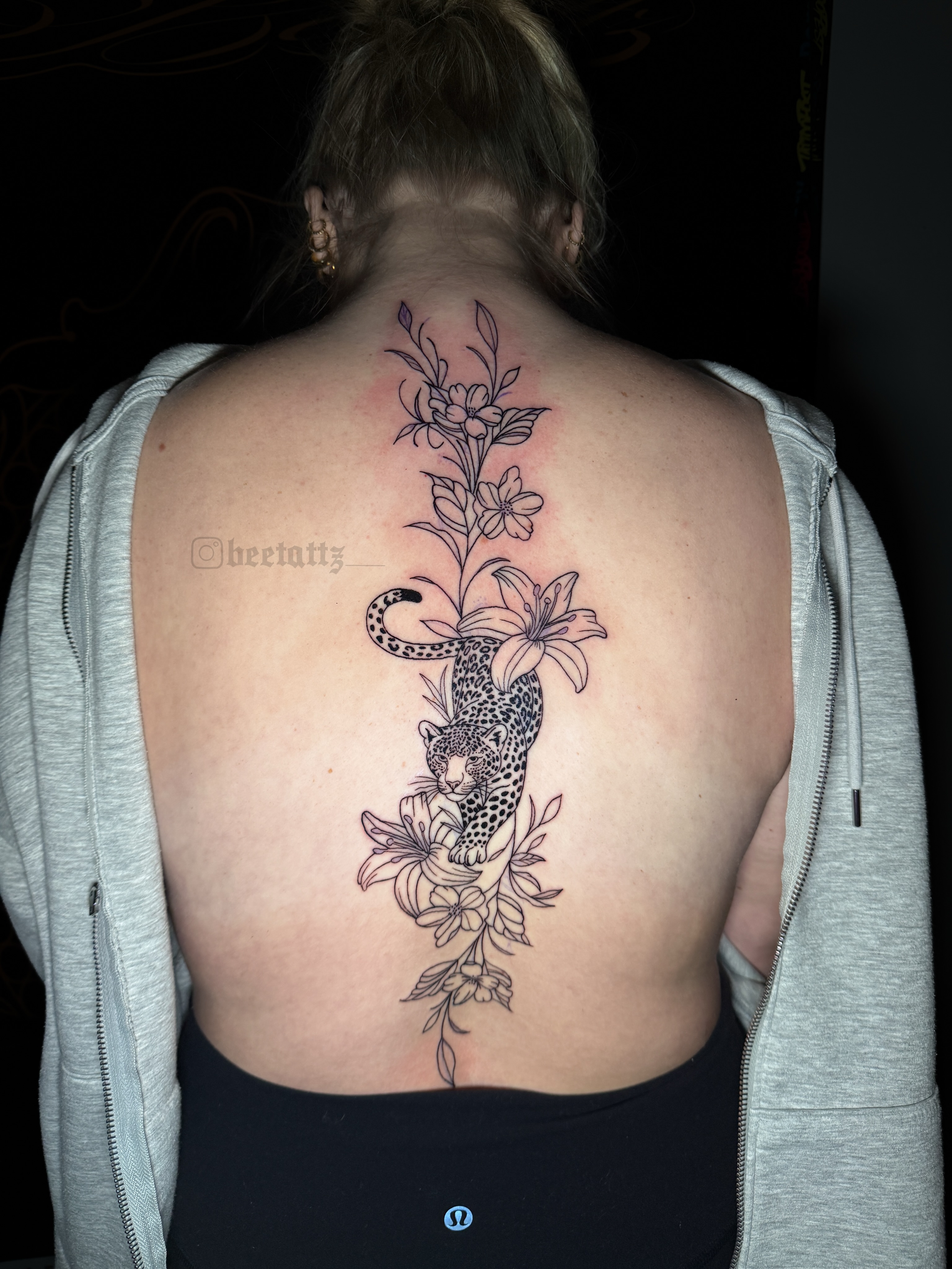 Leopard and flowers black and grey tattoo on the back by Brinkley McGill
