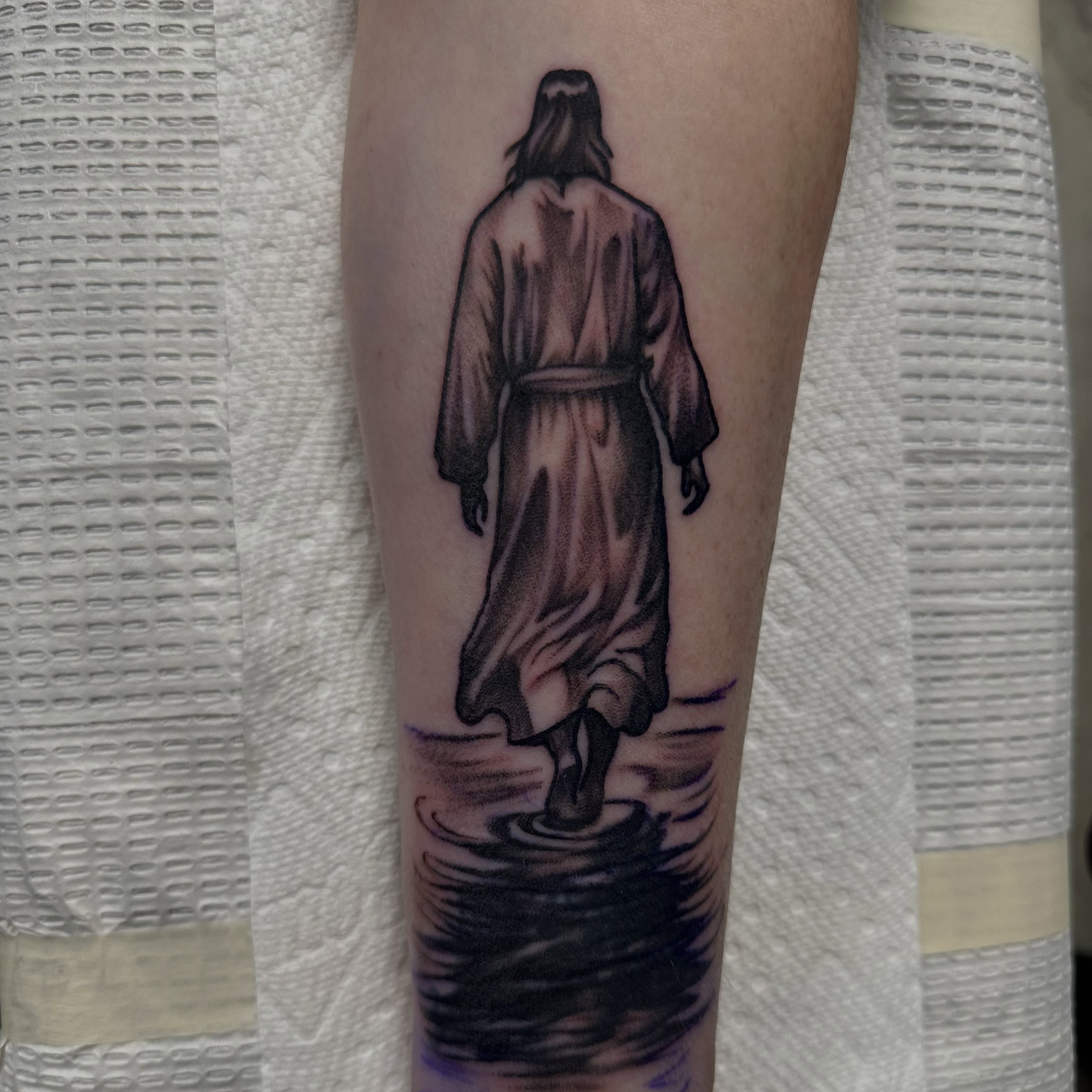 Walking figure black and grey tattoo on the forearm by Vincent Merys