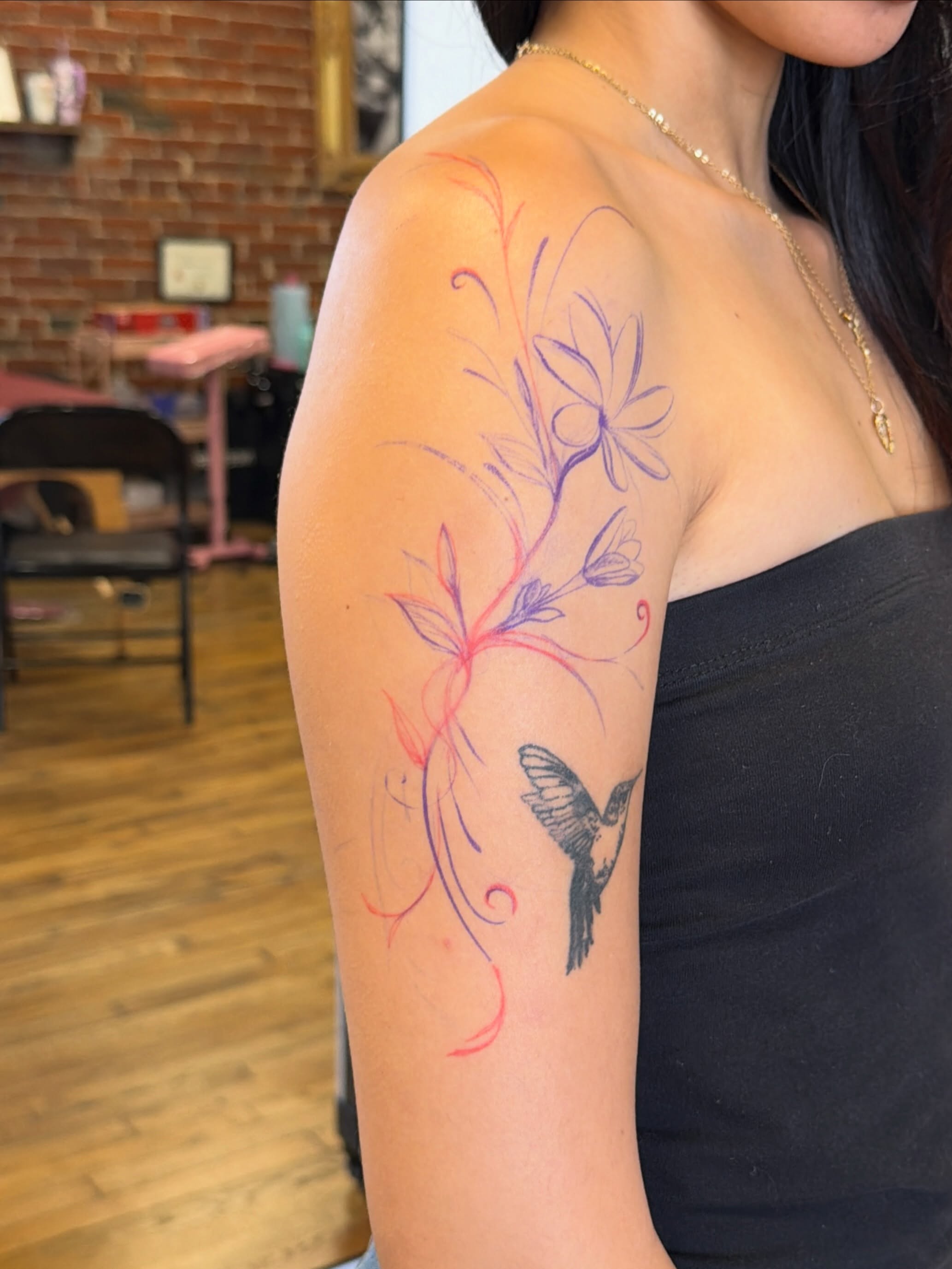 Hummingbird and flowers new school tattoo on the upper arm by Sienna (jj) Hicks