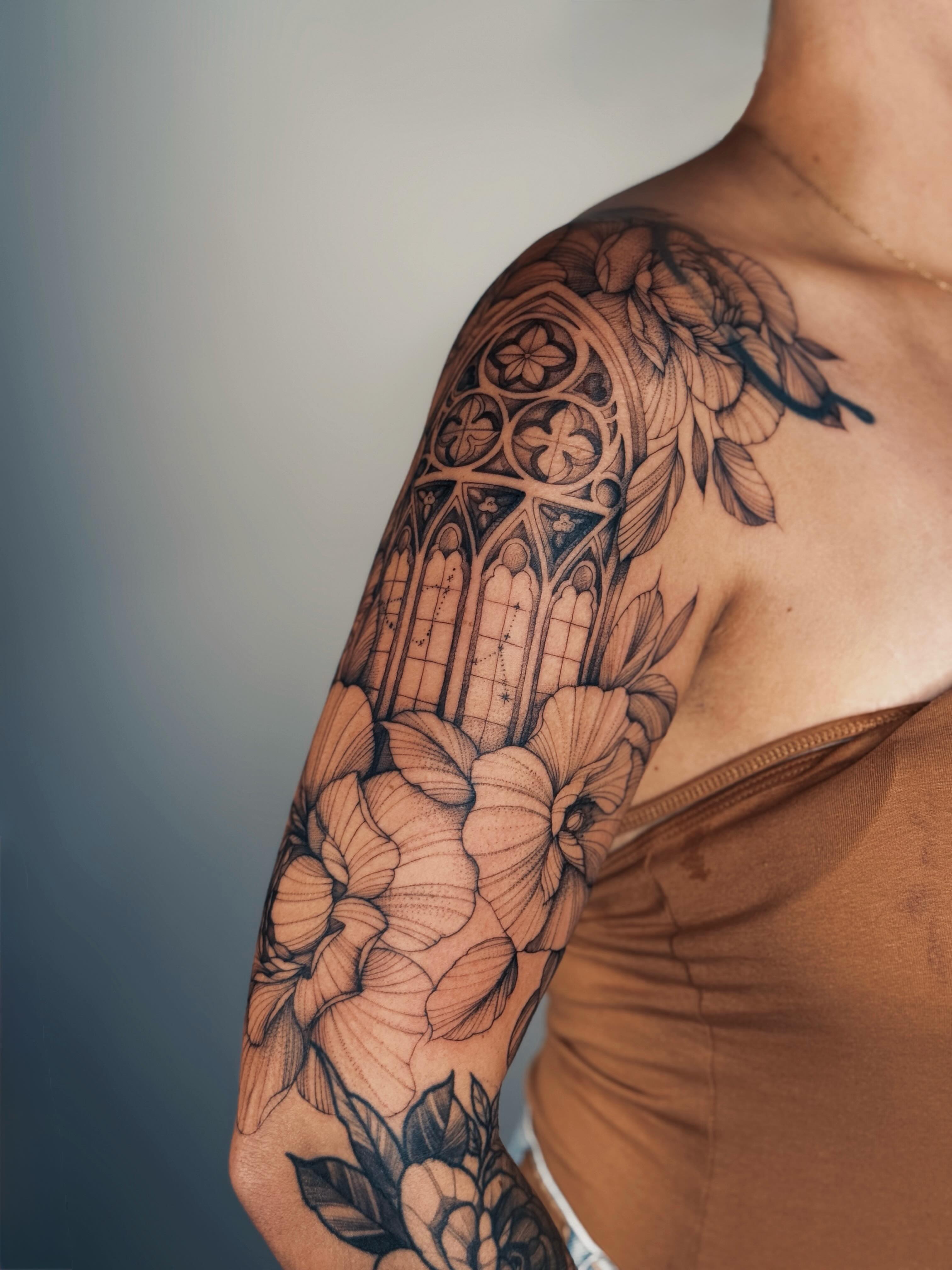Gothic cathedral and floral geometric tattoo on the upper arm by Olha Tytarenko