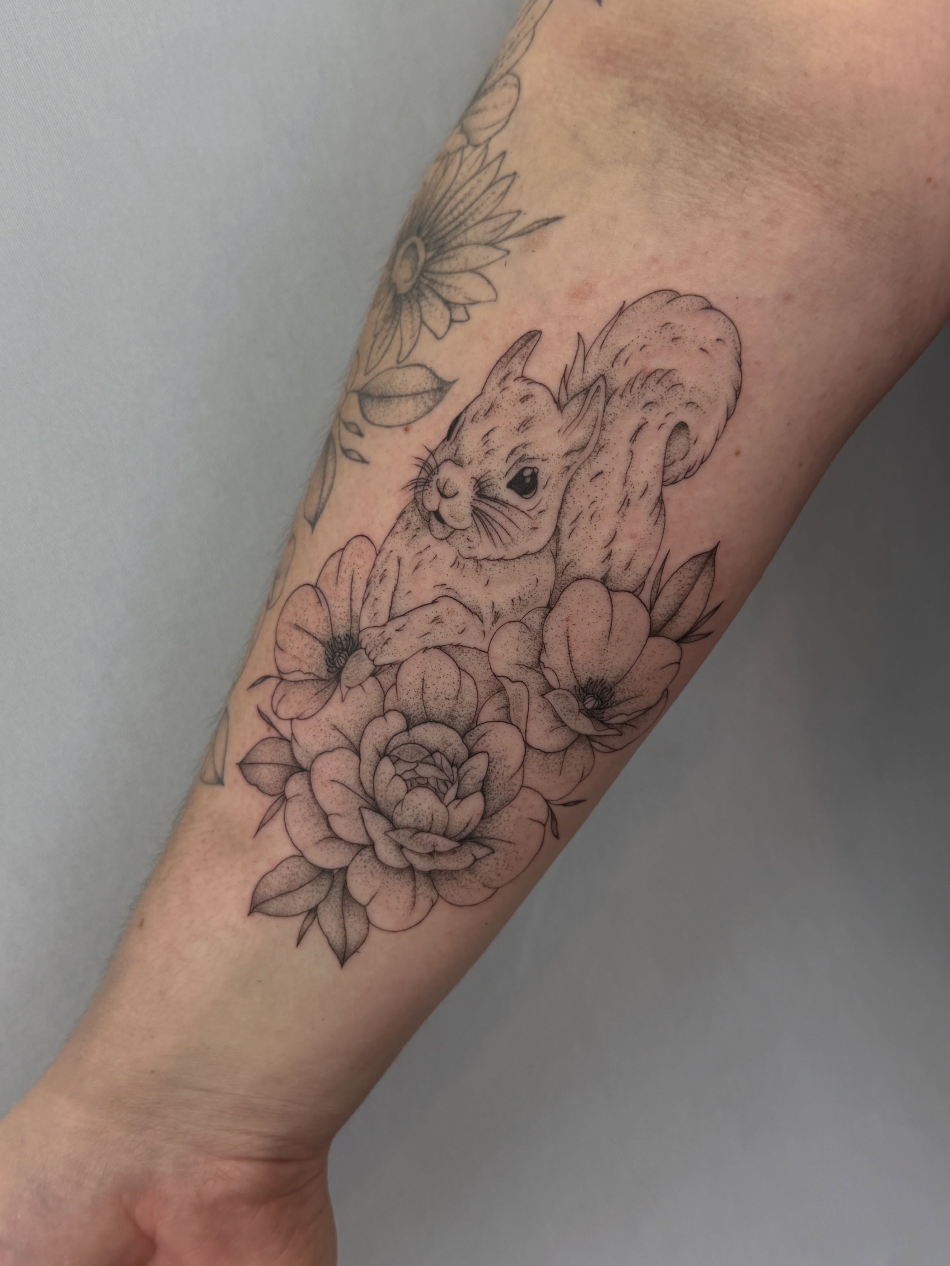 Squirrel and flowers dotwork tattoo on the forearm by Henesee Parfitt