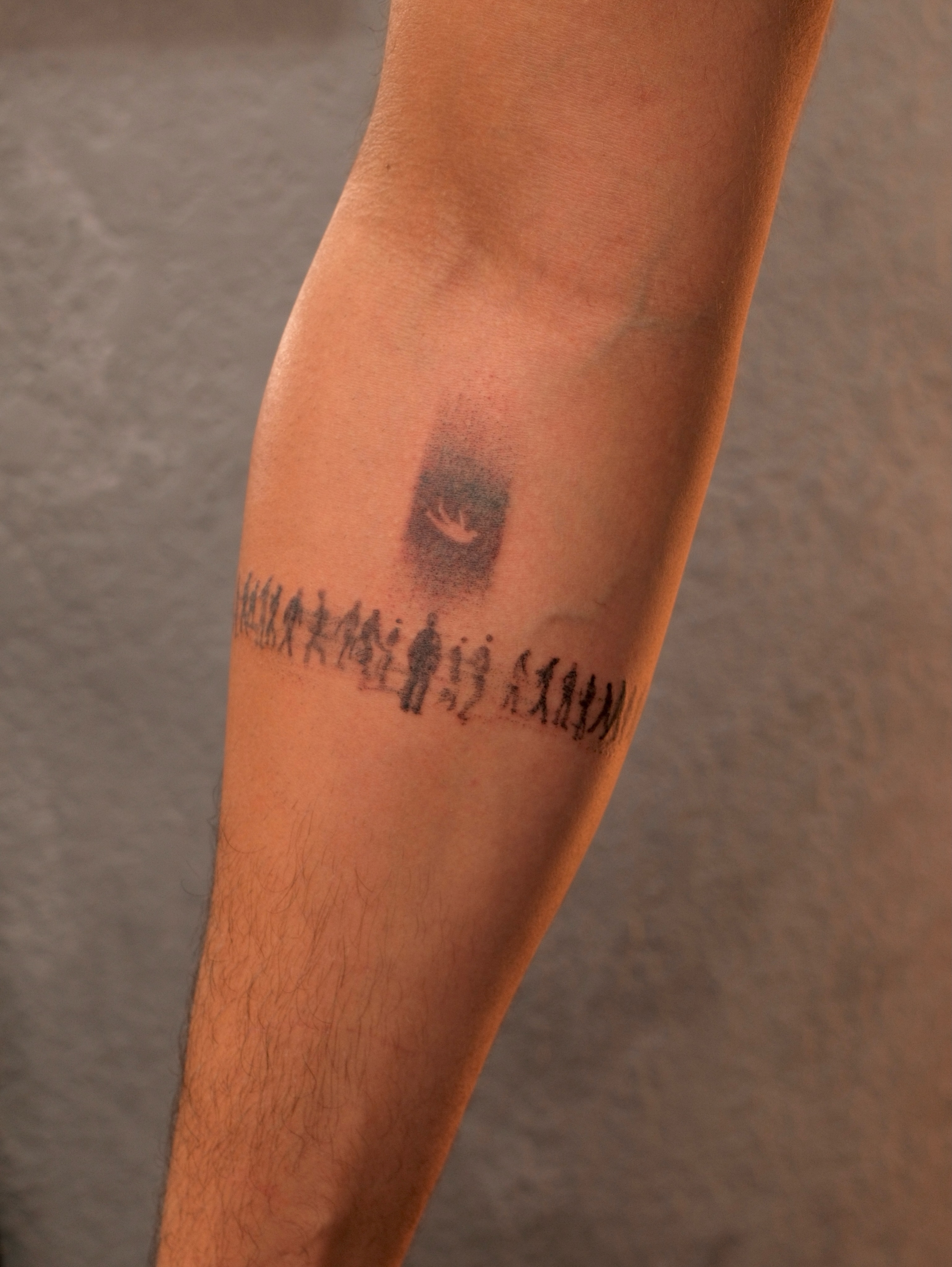 Bird and figures black and grey tattoo on the forearm by Luisa Duarte