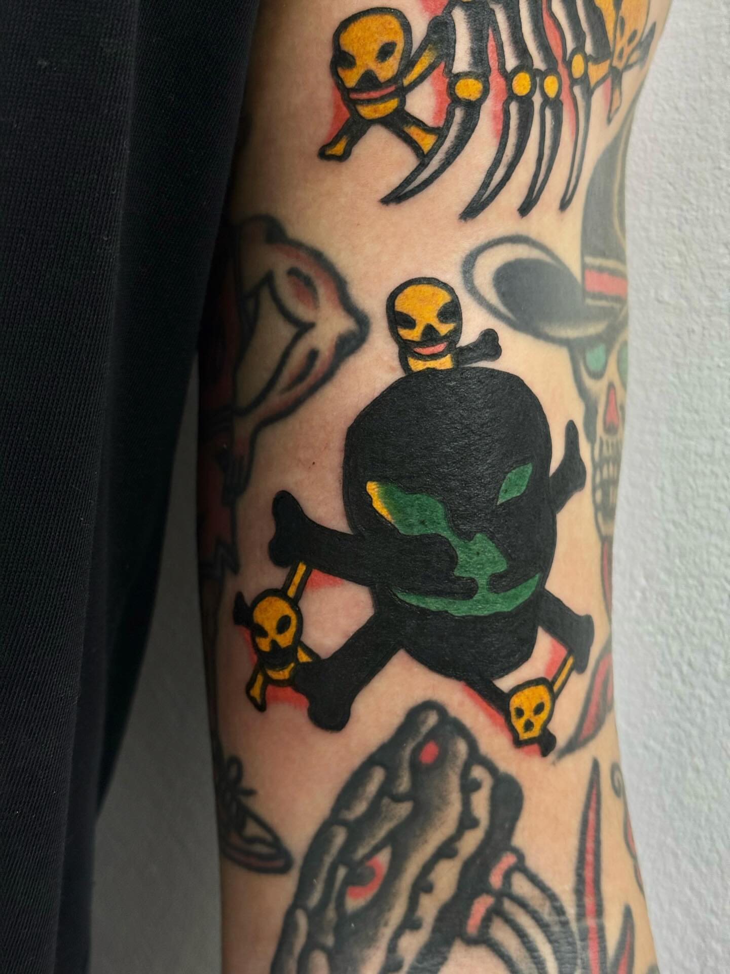 Skull and crossbones American traditional tattoo on the forearm by JAX