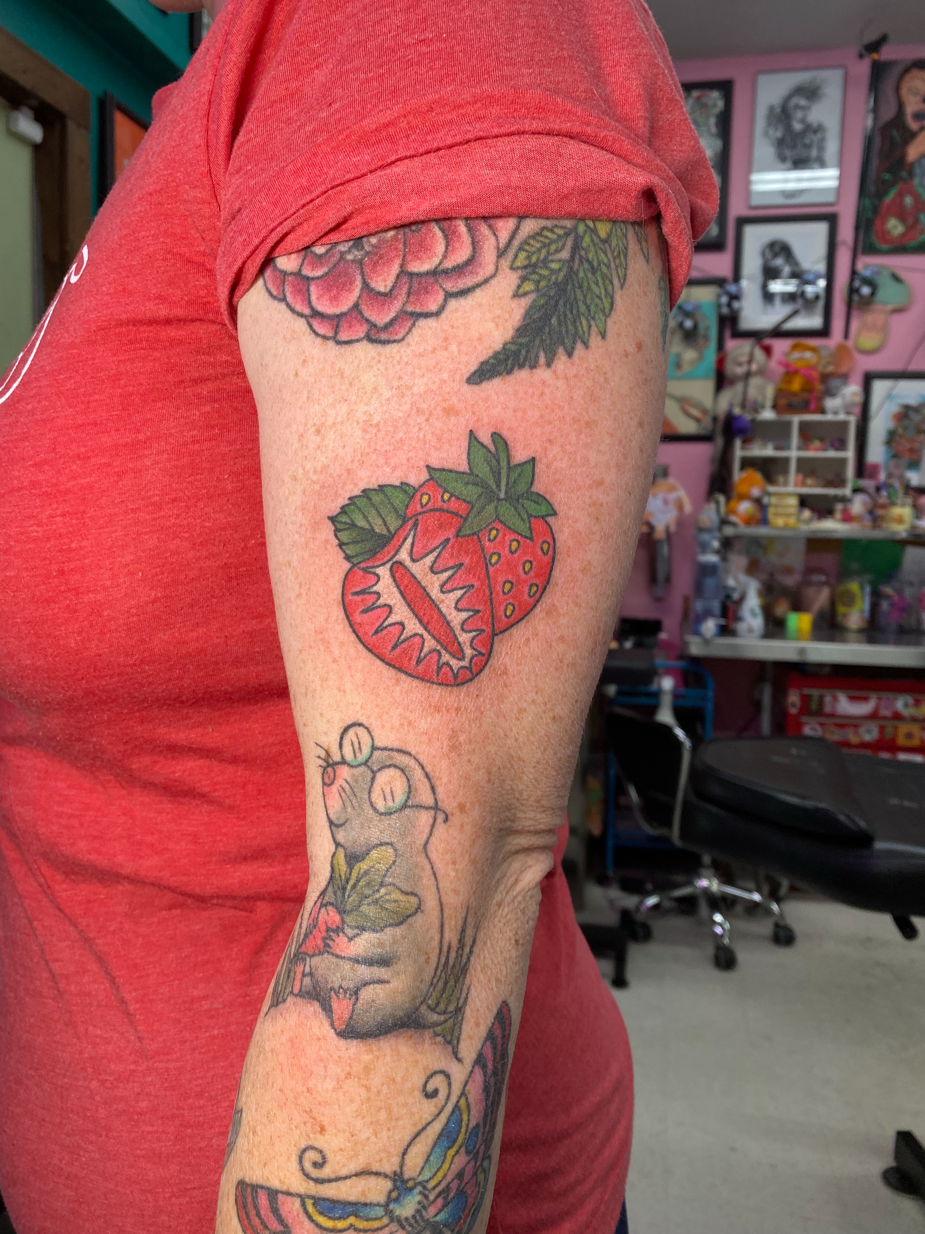 Strawberry and hand American traditional tattoo on the forearm by Ramsie Segura-Andrews