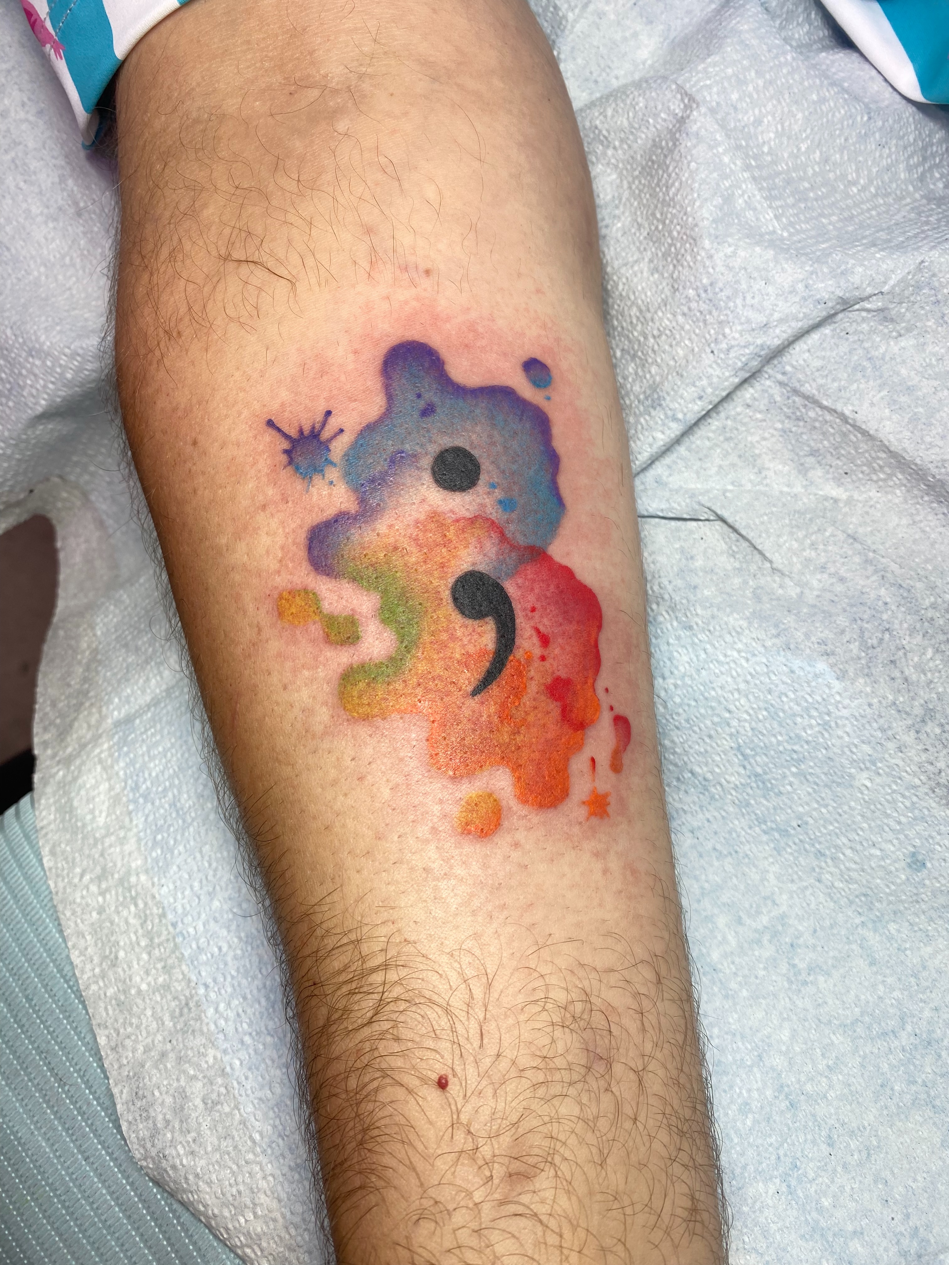 Comma watercolor tattoo on the forearm by Ramsie Segura-Andrews