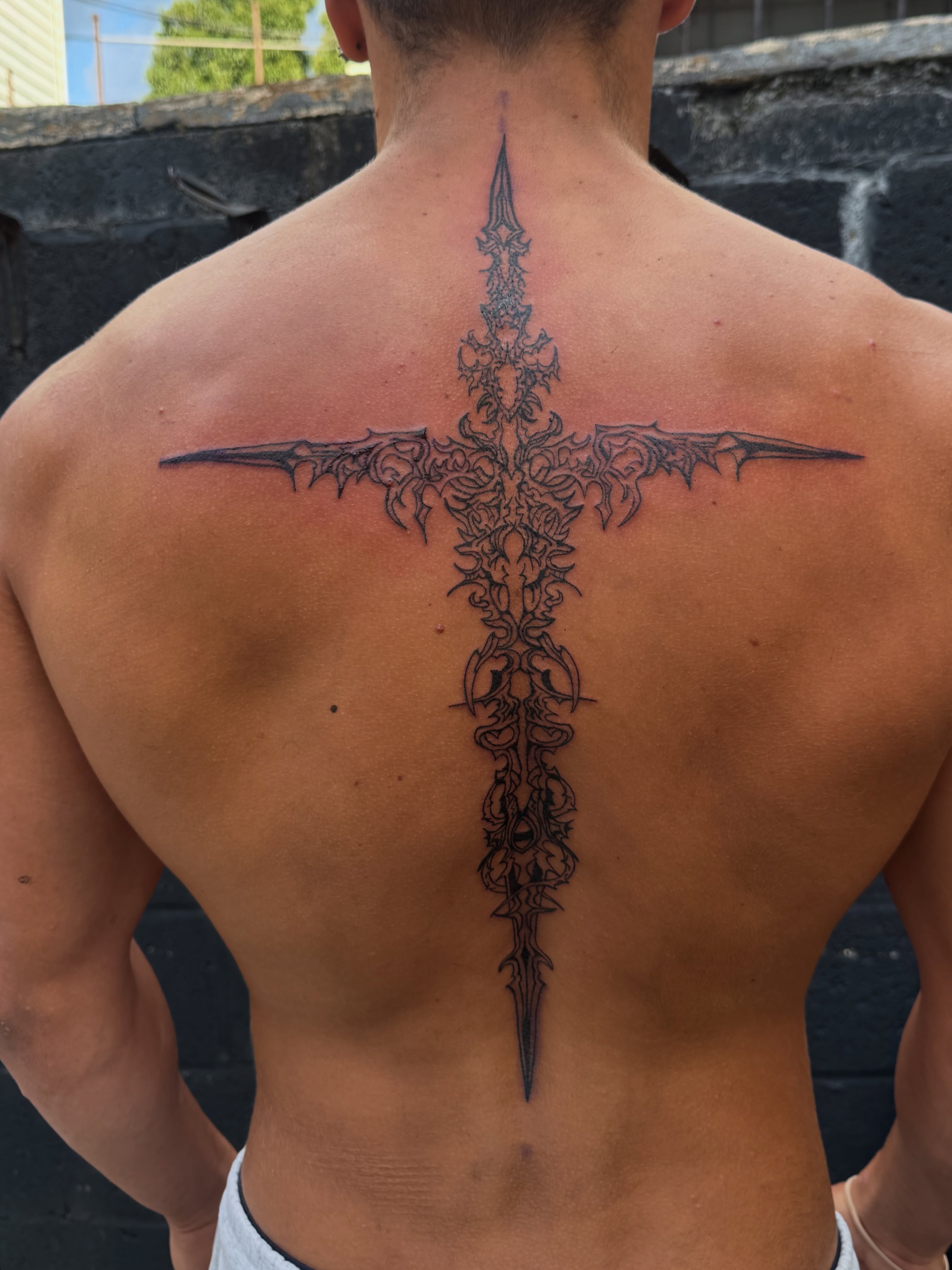 Cross ornamental tattoo on the back by dev