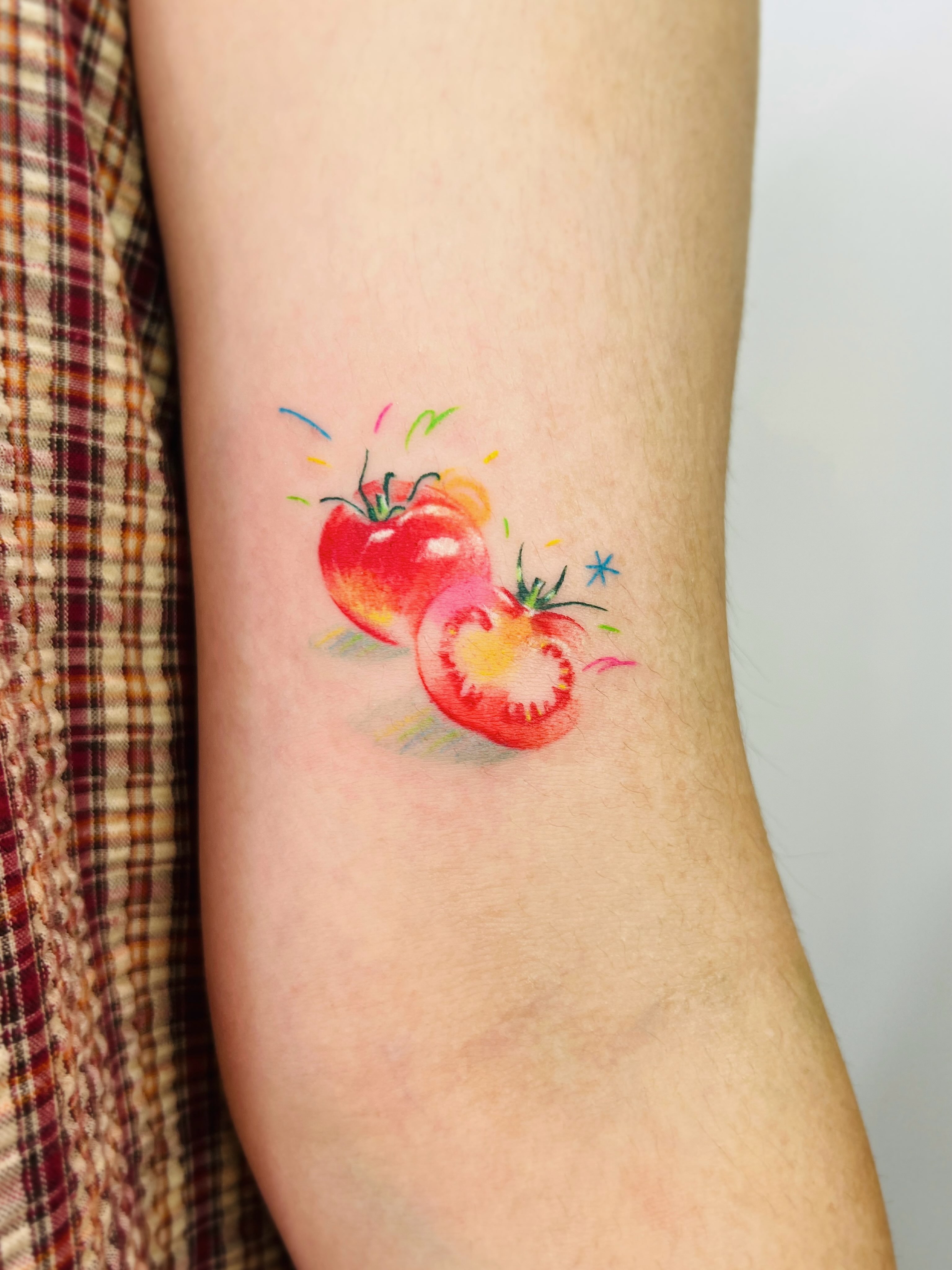 Tomatoes watercolor tattoo on the forearm by Purinn