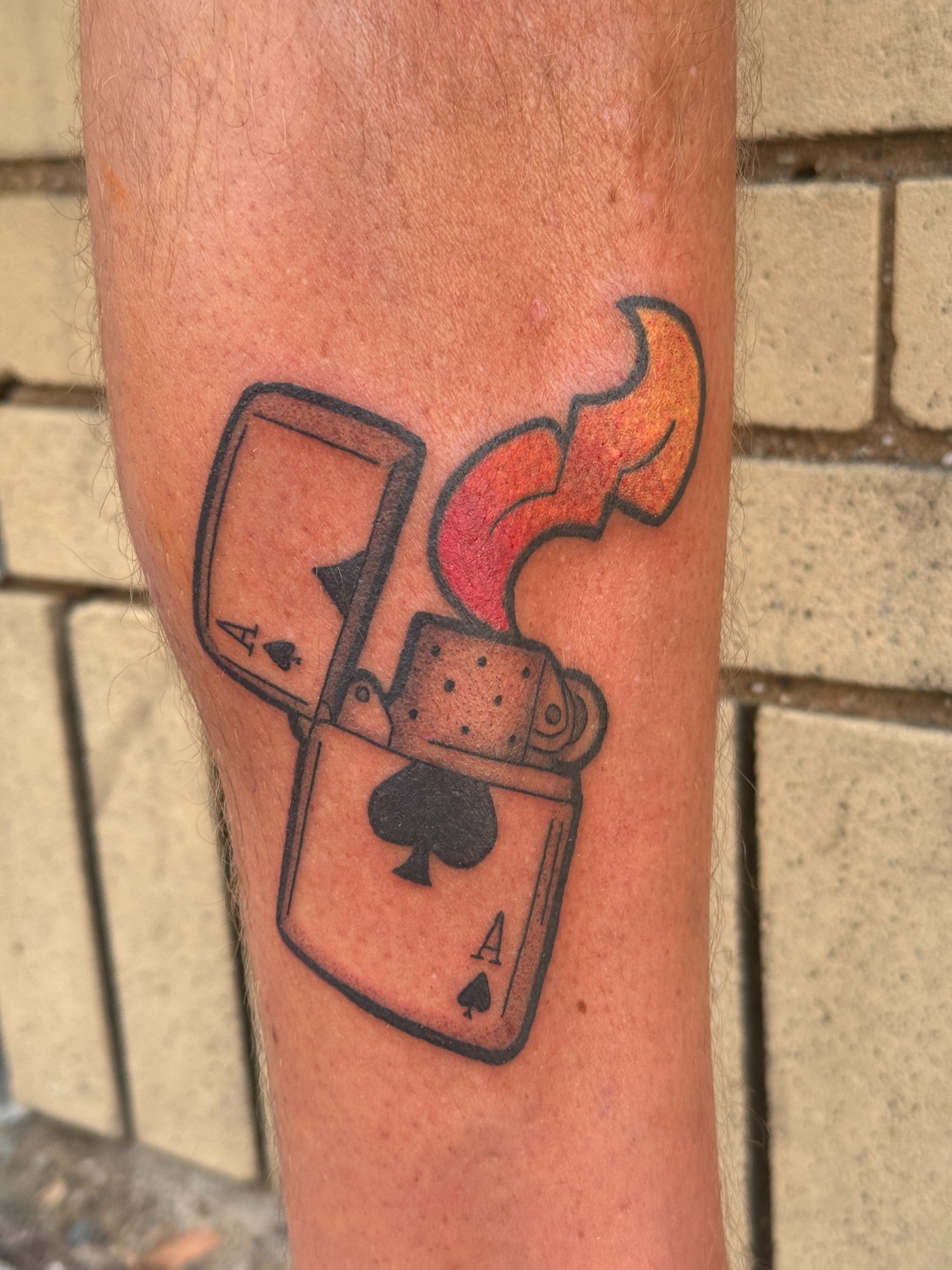Playing card and lighter black and grey tattoo on the forearm by Mo