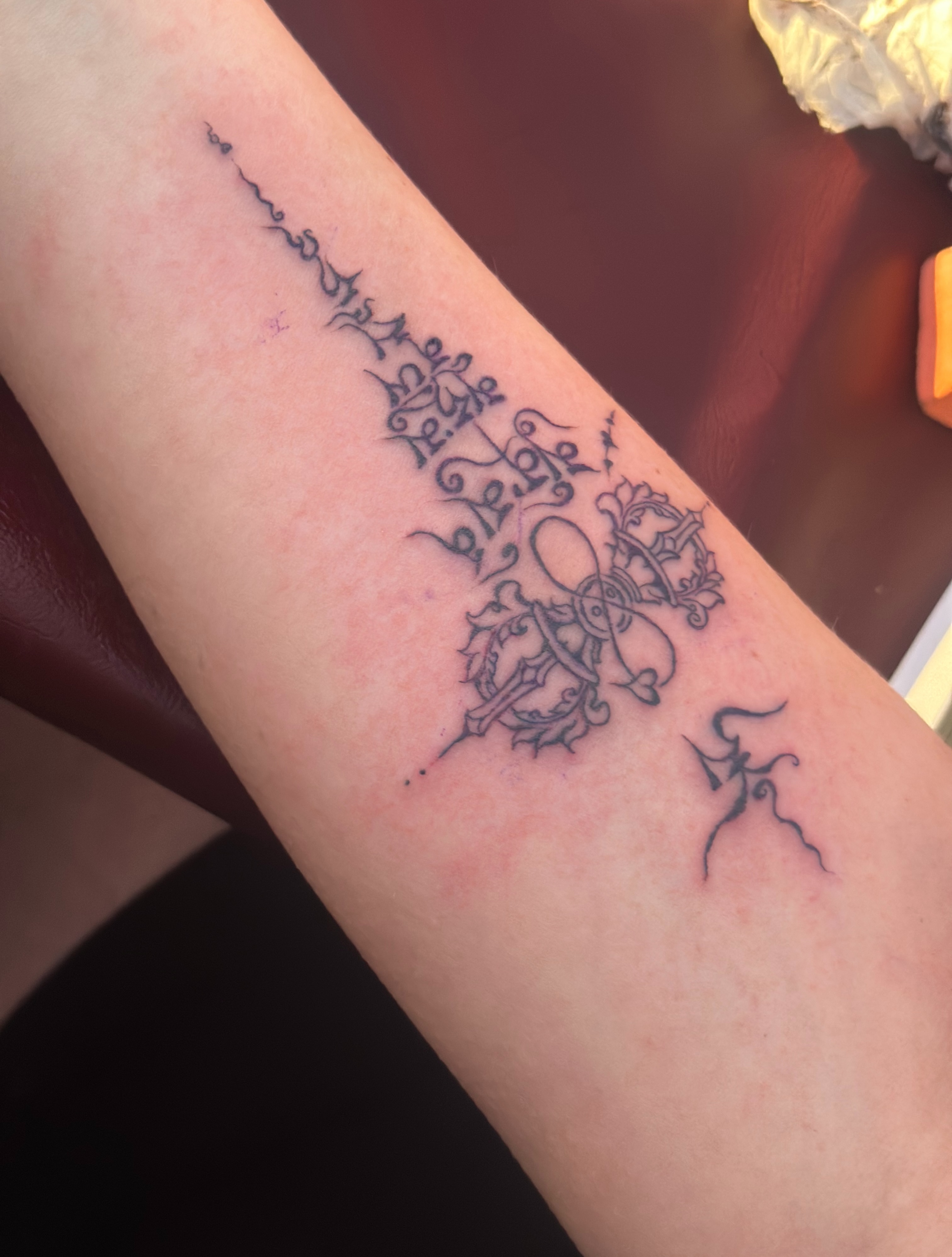 Cross with floral and symbolic elements ornamental tattoo on the forearm by Lama *Tashi *Norbu, Emmen, Drenthe
