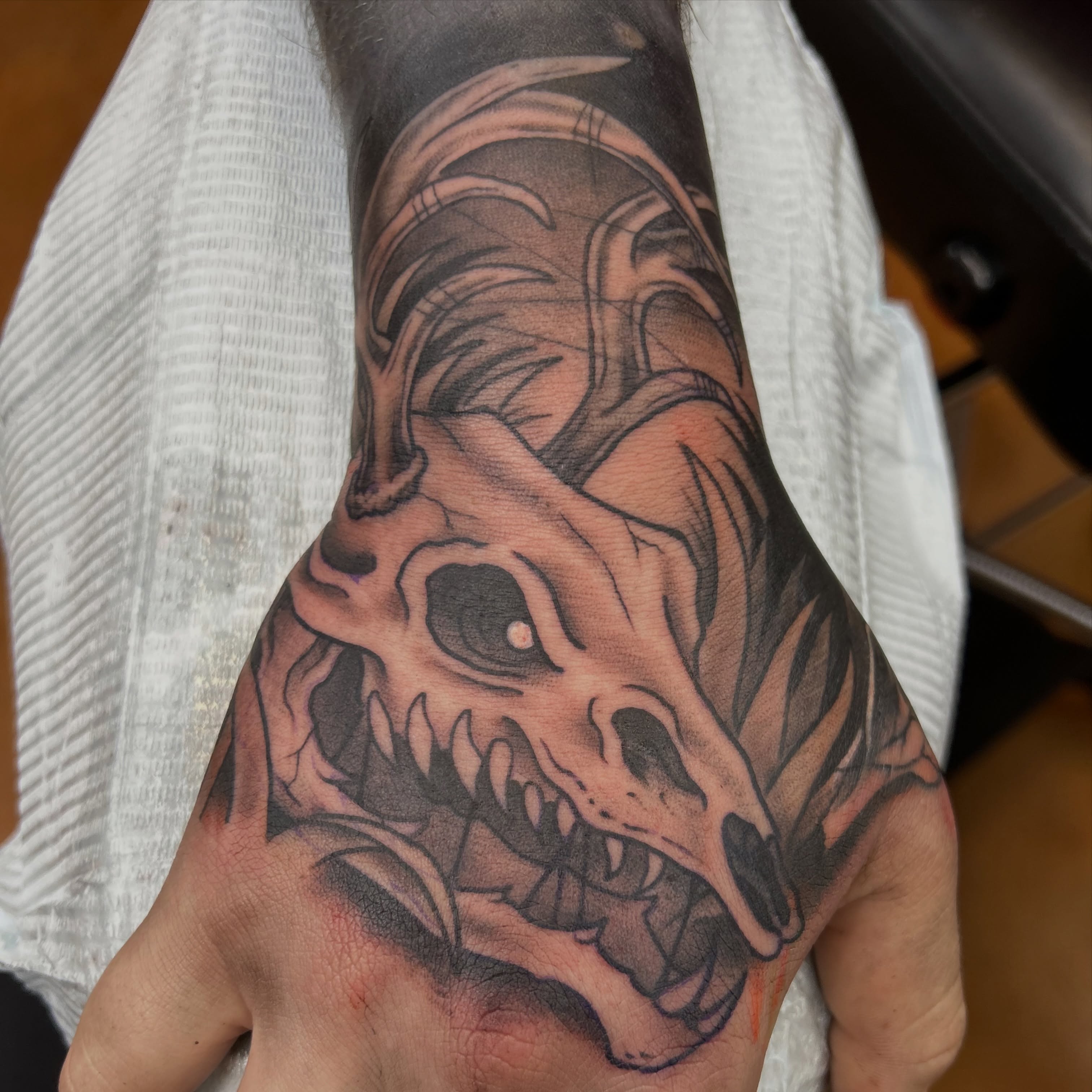 Skull black and grey tattoo on the hand by Alex Byrne