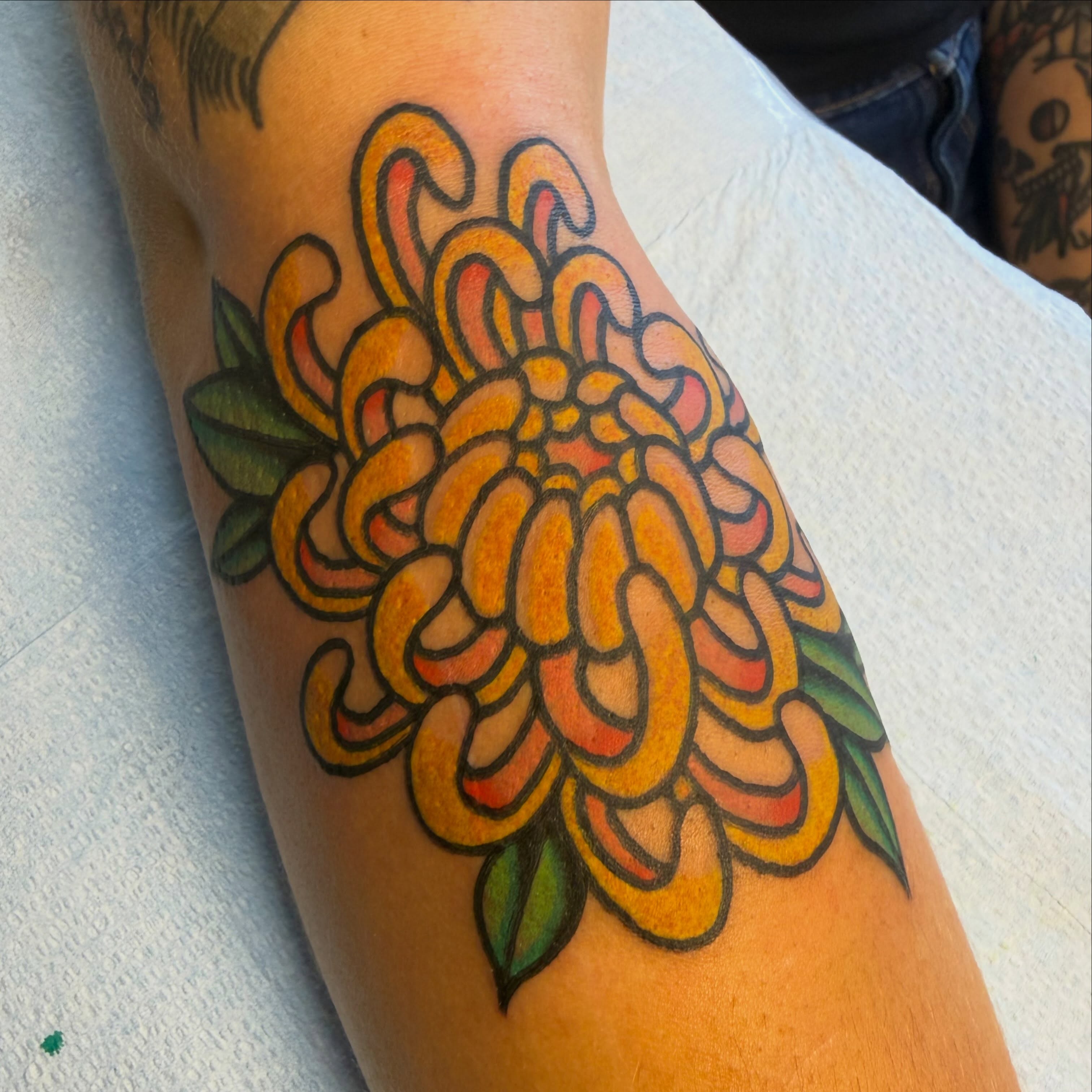Chrysanthemum American traditional tattoo on the forearm by Tyler