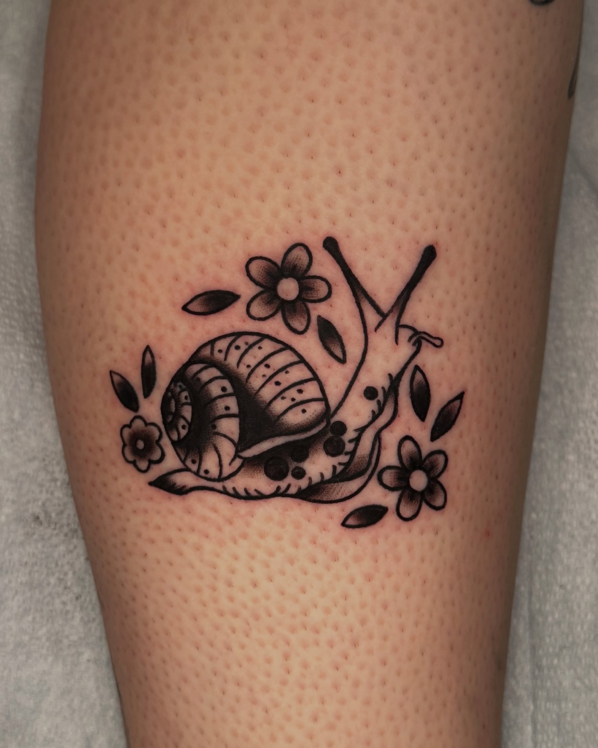 Snail black and grey tattoo on the forearm by Paige Ochoa