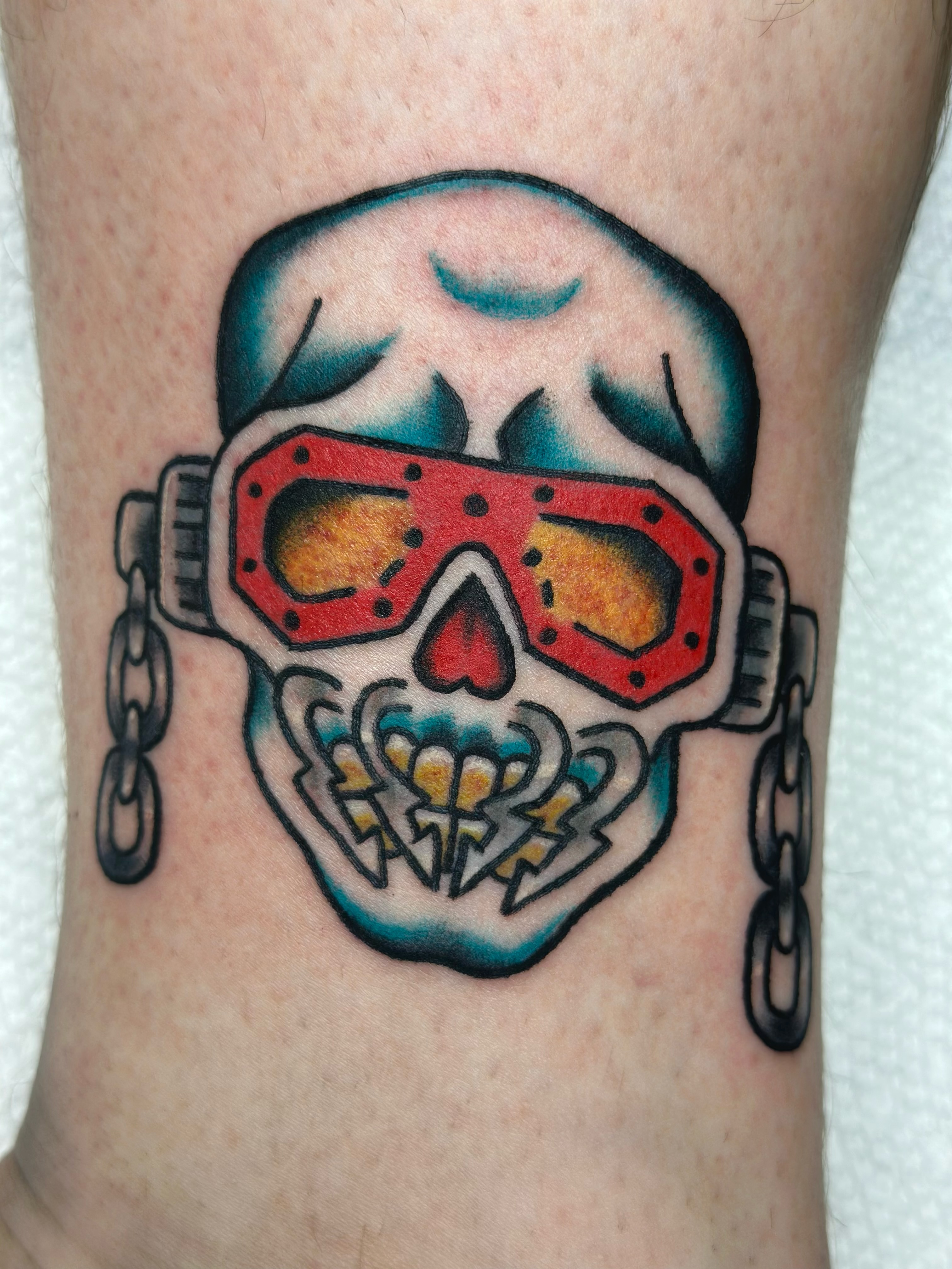 Skull with goggles American traditional tattoo on the forearm by Lucy Jay