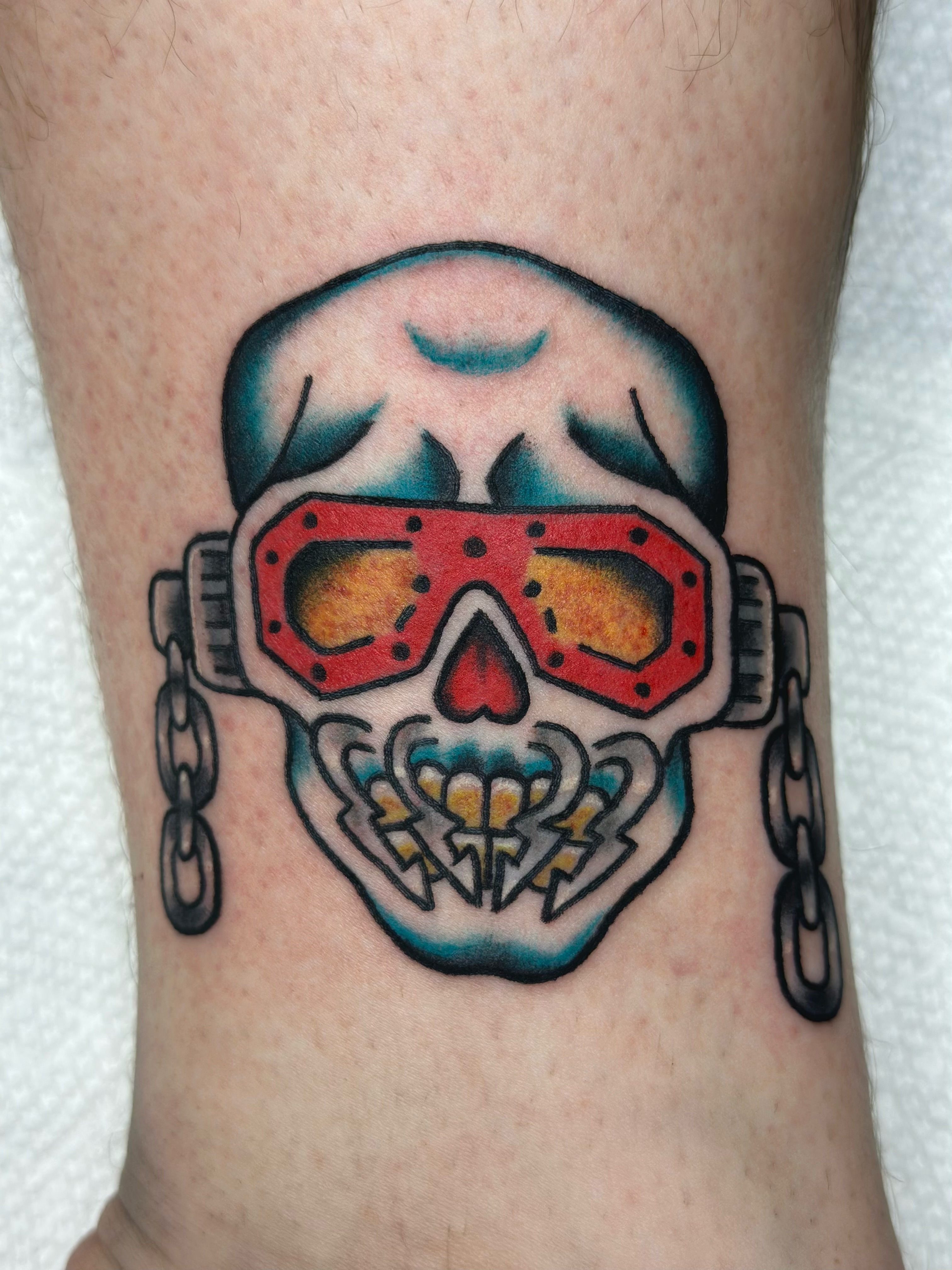 Skull with goggles American traditional tattoo on the forearm by Lucy Jay