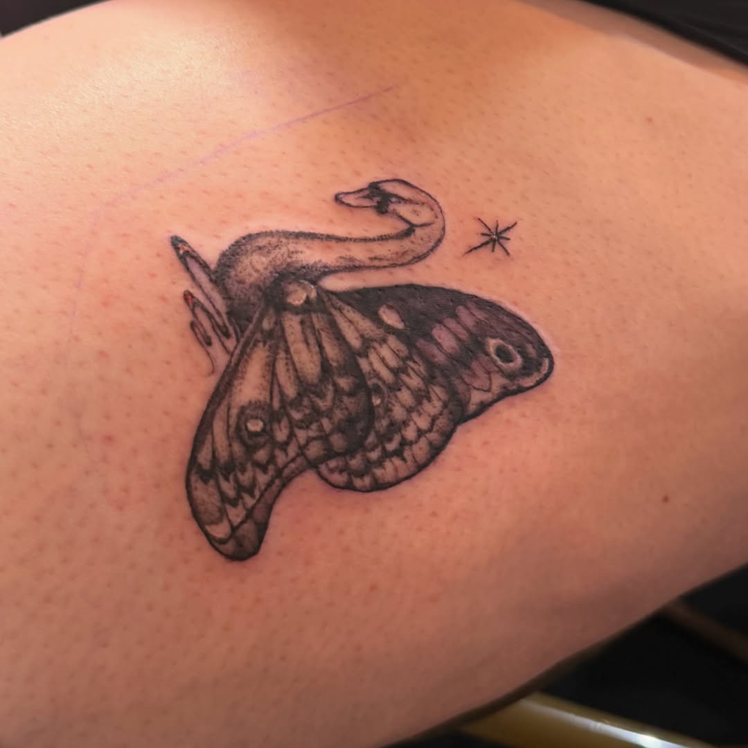 Moth and snake black and grey tattoo on the upper arm by Nina Nichole